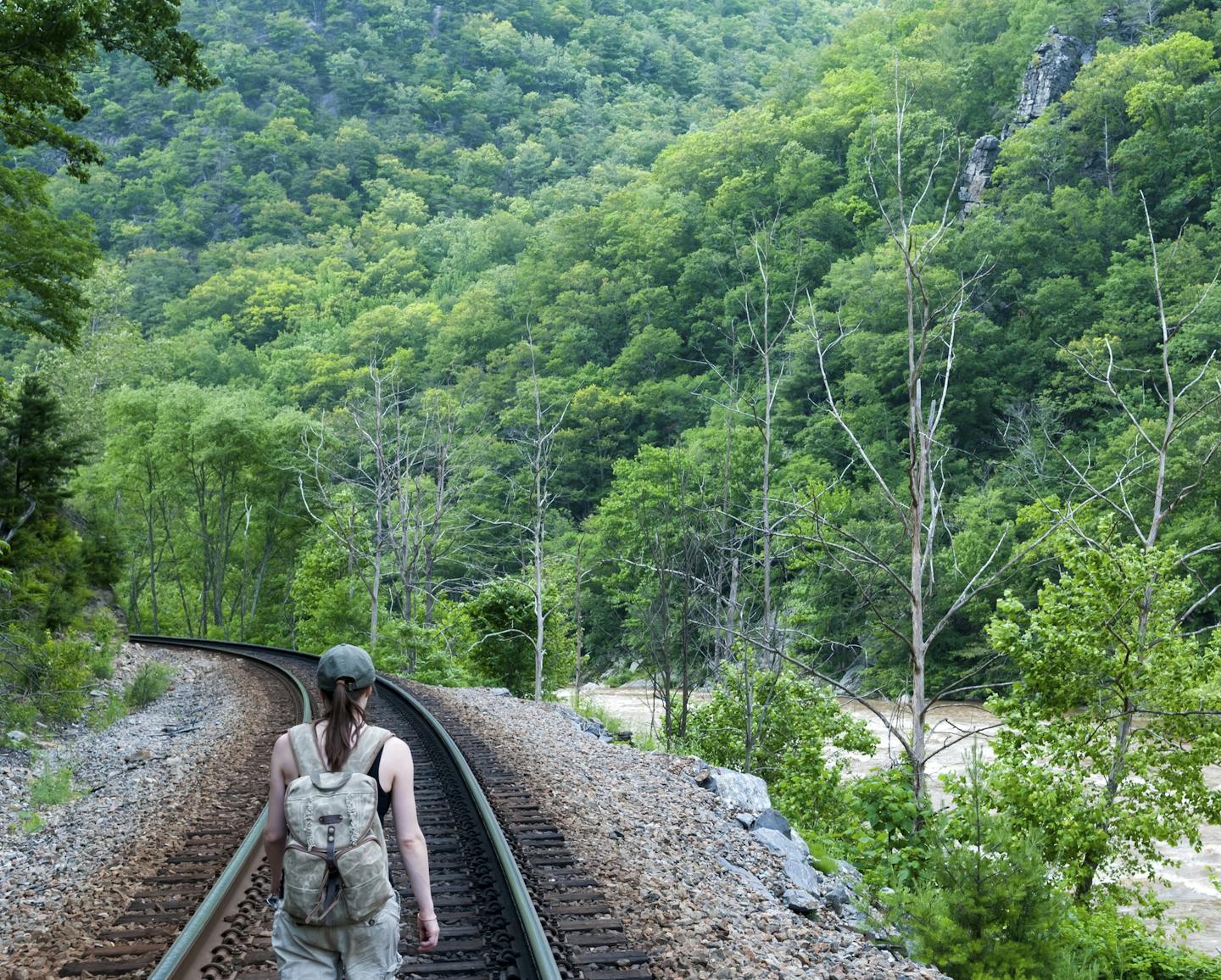 A young woman walking alone down a railroad track in Appalachia (near Erwin, TN)