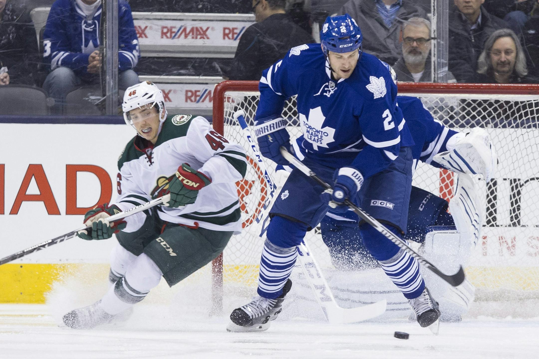 Toronto Maple Leafs' Eric Brewer, right, clears the puck away from Minnesota Wild's Jared Spurgeon during the second period of an NHL hockey game in Toronto, Monday, March 23, 2015.
