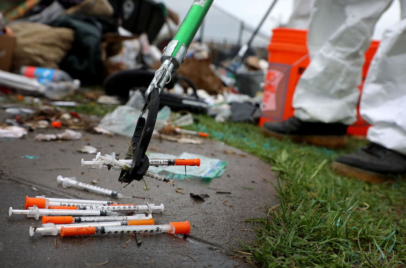 Pride Cleanup workers remove waste in a homeless encampment dubbed: "Camp Quarantine," off of Hiawatha Avenue on the day after the Memorial Holiday weekend Monday, May 25, 2020, in Minneapolis, MN. Here, Here, crew leader Rajah Smith uses a trash picker to removed discarded needles during a hot, humid Memorial Day cleanup.]