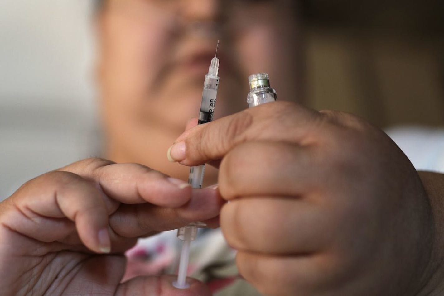 FILE - In this April 18, 2017 file photo, a woman with Type 2 diabetes prepares to inject herself with insulin at her home in Las Vegas. The skyrocketing price of insulin has some diabetics scrambling to cover the cost of the life-saving medication. Others are skipping doses or using smaller amounts than needed, and sometimes landing in the ER, patients and advocates told Congress in April 2019.