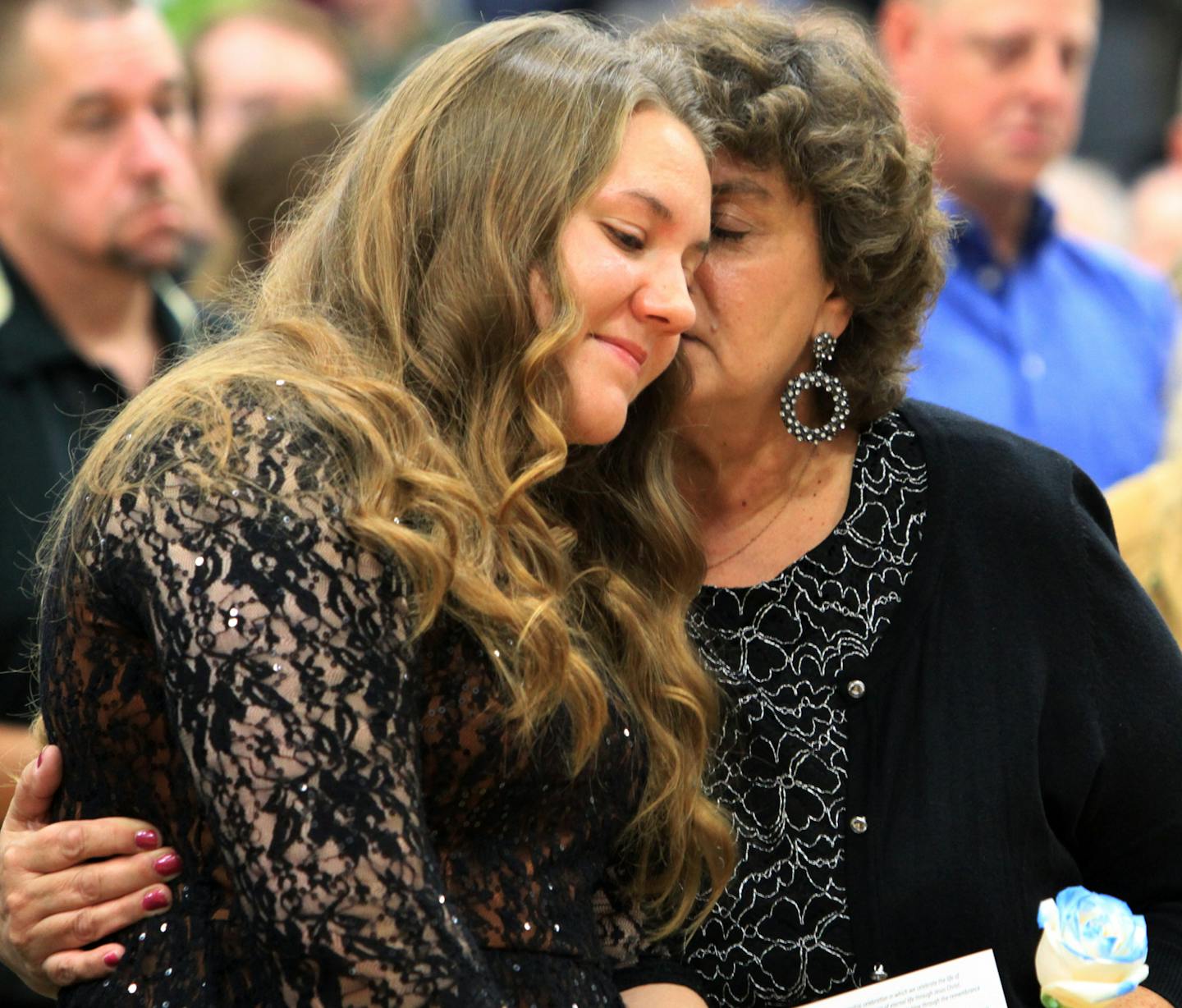 Thousands of law enforcement officers poured into Aitkin on a drizzly morning to bury one of their own, Deputy Steven M. Sandberg. Here, his daughter Cassie and wife Kristi embrace during the funeral service. ] POOL PHOTO BY JENNIFER LONGAECKER