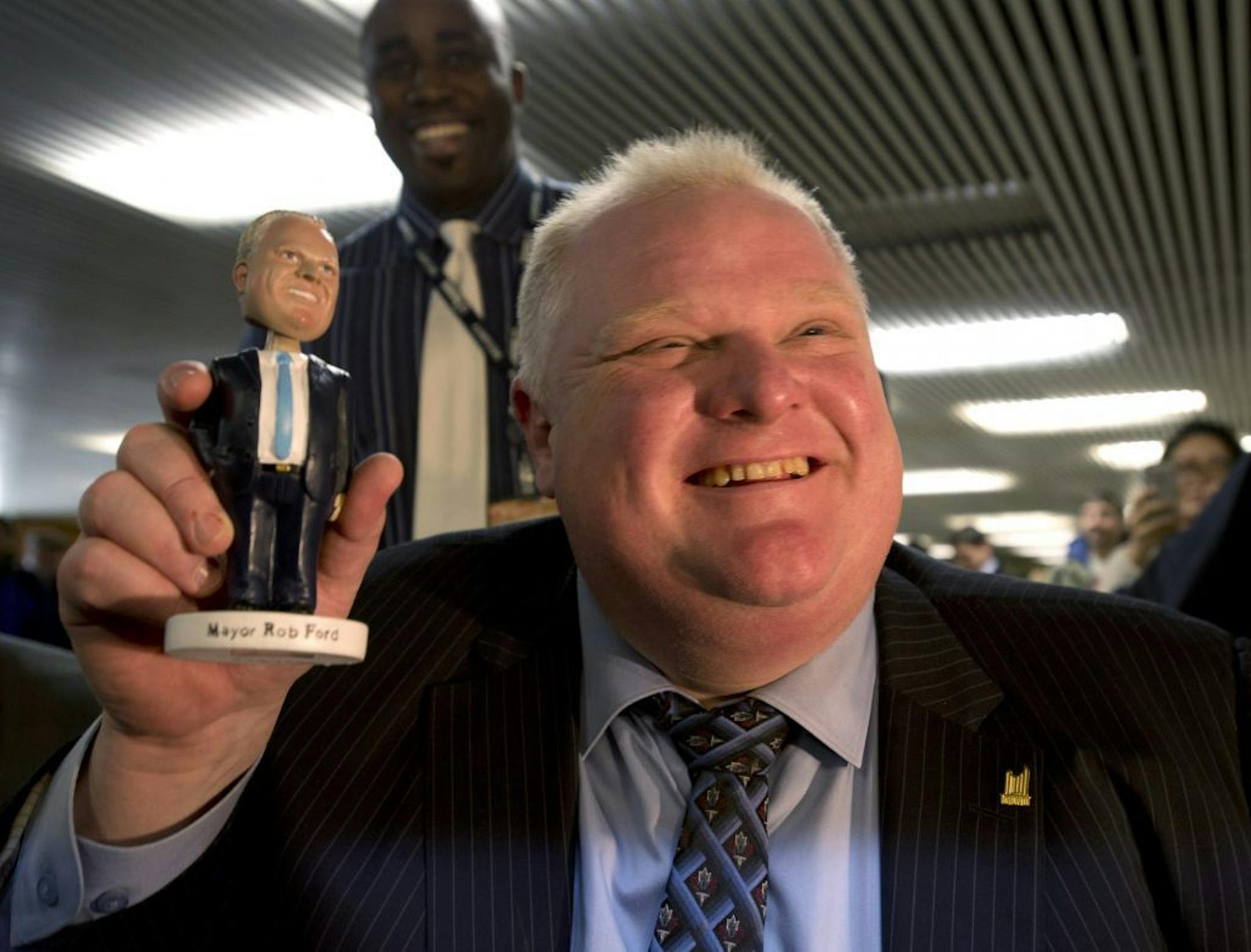 Toronto Mayor Rob Ford holds a Rob Ford bobblehead doll of himself at Toronto city hall on Tuesday, Nov. 12, 2013.