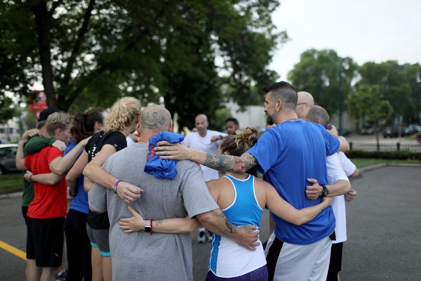 Before and after every run, members of the Mile In My Shoes running group huddle up to encourage each other. The group, pictured here on a 2018 run, connects people living in shelters or halfway houses with running mentors from the community.