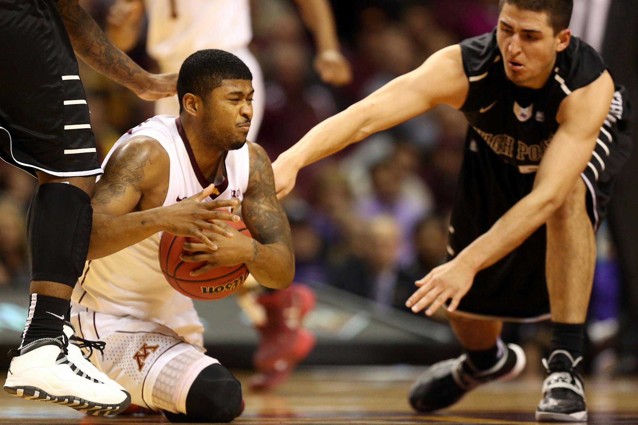 Gopher Maverick Ahanmisi went f to the floor after being fouled by High Point's Lorenzo Cugini in the second half. ] (KYNDELL HARKNESS/STAR TRIBUNE) kyndell.harkness@startribune.com First round of the National Invitational Tournament at Williams Arena in Minneapolis Min, Tuesday March 18, 2014. Gophers won 88-81 over High Point.