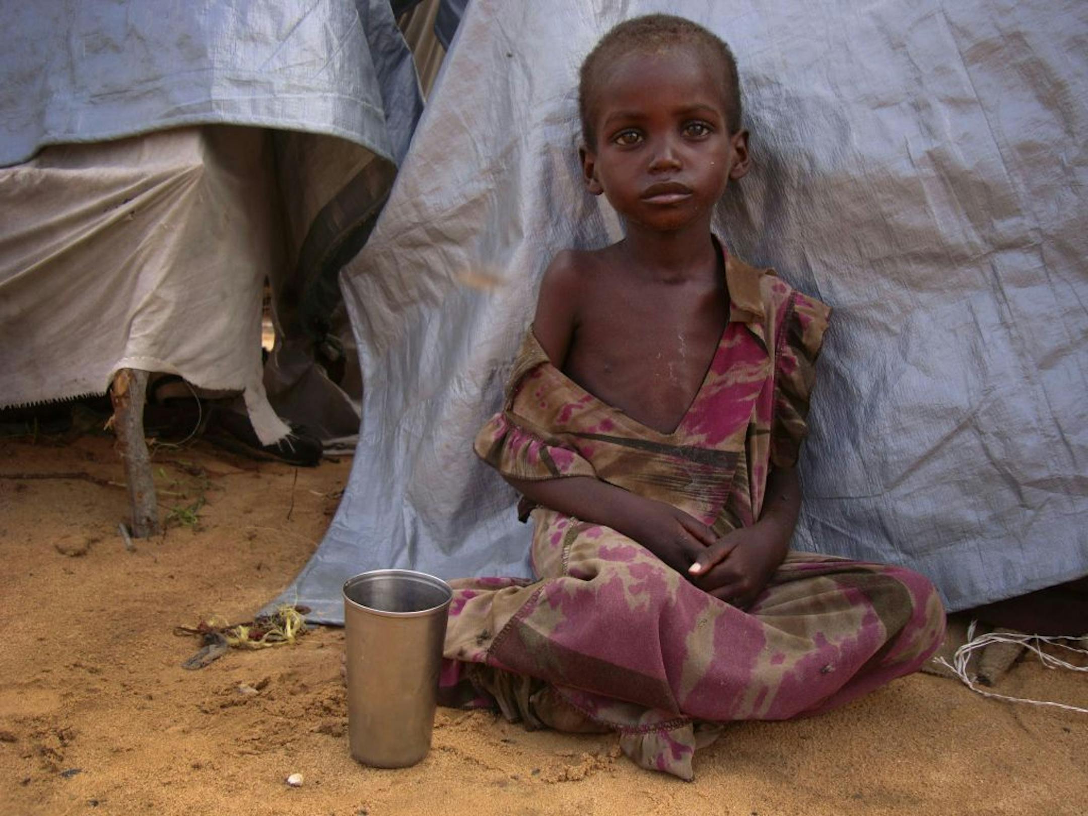 A girl from southern Somalia sits outside a makeshift shelter at a refugee camp in Mogadishu, Somalia, Tuesday, Aug 9, 2011. She's among the large number of people fleeing famine-hit areas of Somalia.