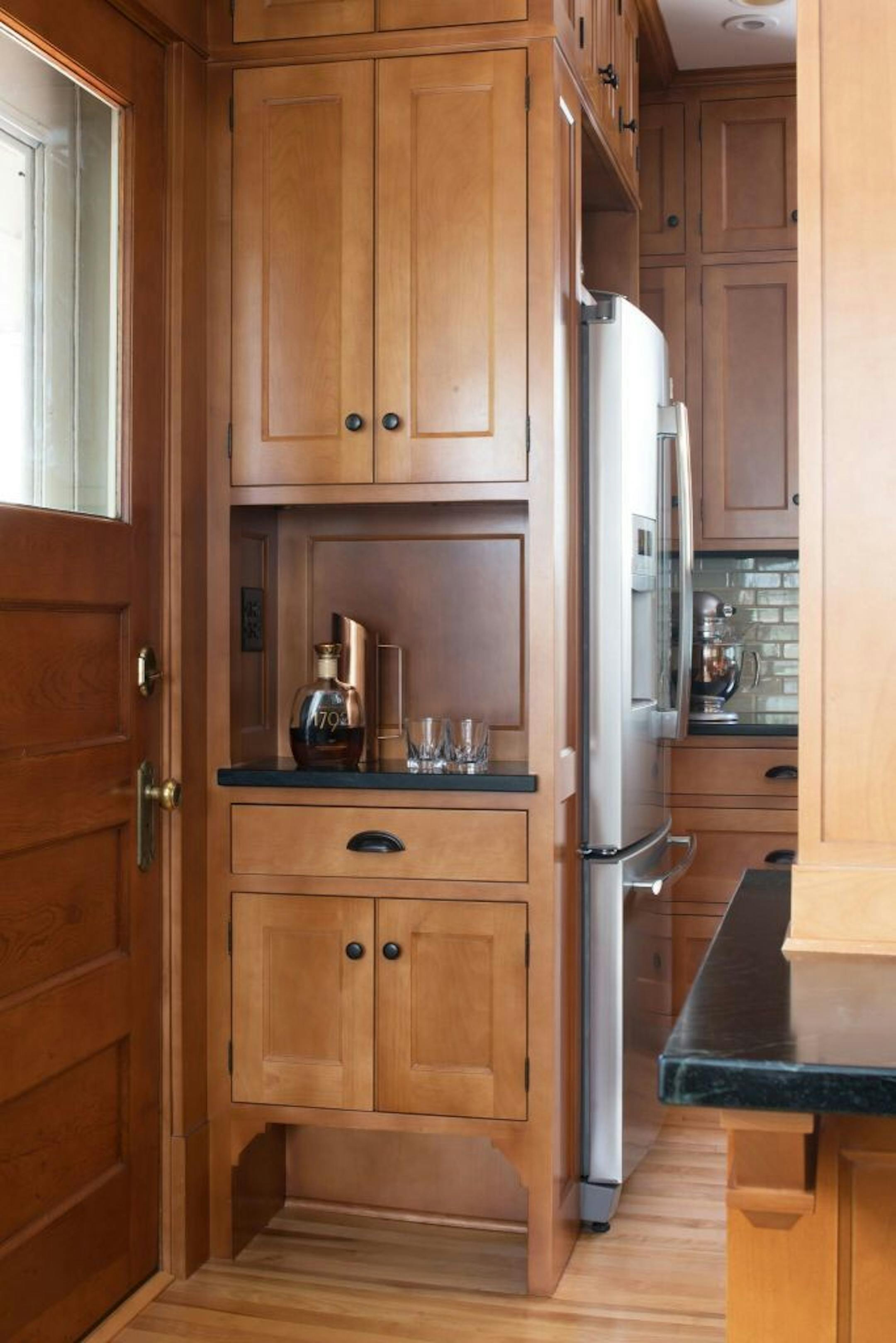 Cabinets near the back door have a cutout at the bottom for storing shoes.