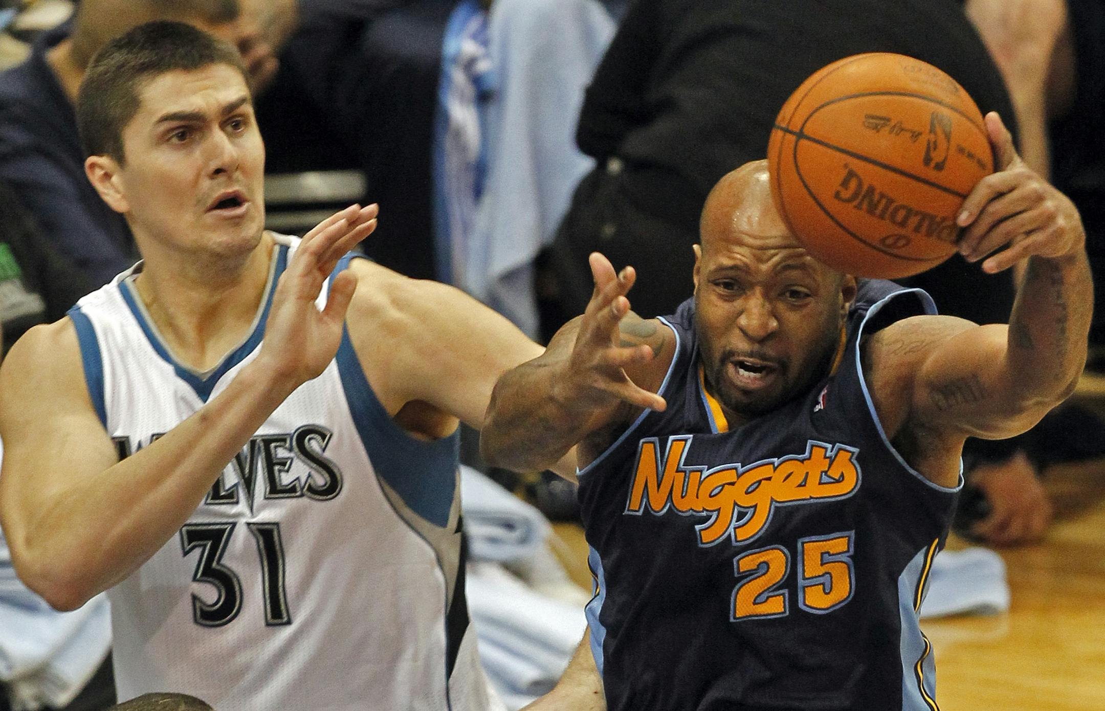 Wolves Darko Milicic, left and Denver's Anthony Carter fought for control of a rebound.