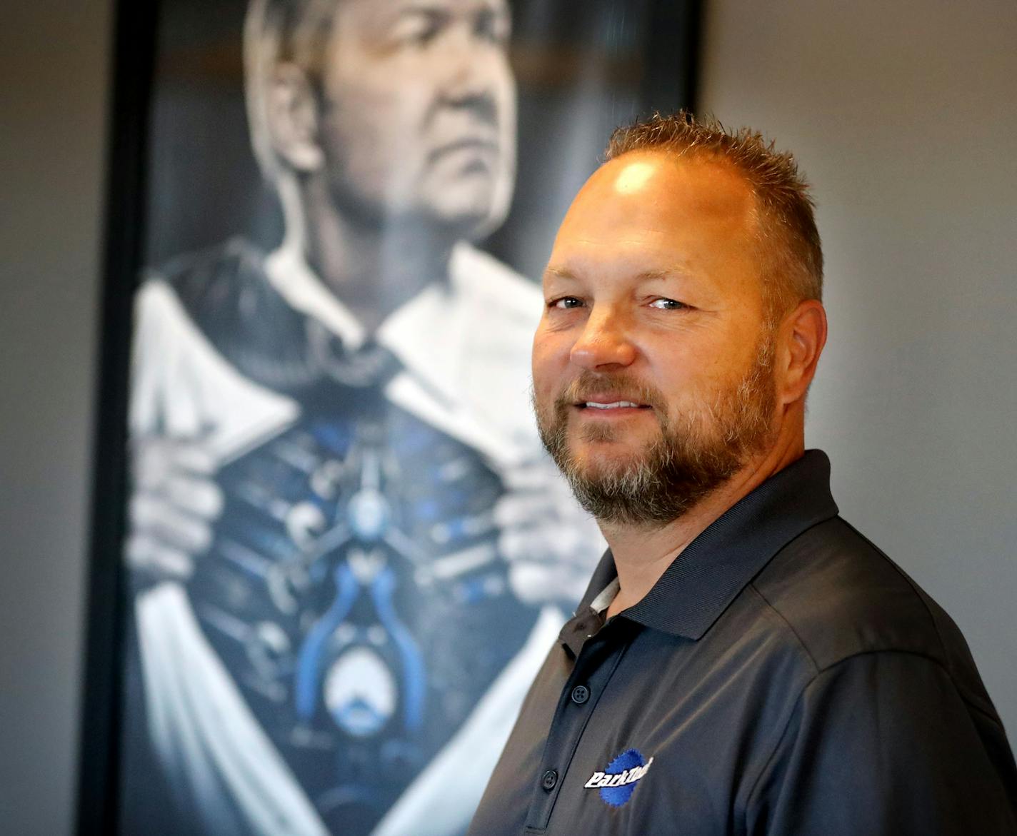 Park Tool owner and chief mechanic Eric Hawkins near an artist's rendering of Hawkins in the lobby of Park Tool, a giant in the world of bicycle maintenance and repairs, Thursday, Nov. 10, 2016, at Park Tool in St. Paul, MN.] (DAVID JOLES/STARTRIBUNE)djoles@startribune.com profile of Eric Hawkins, owner and chief mechanic, Park Tool**Eric Hawkins,cq