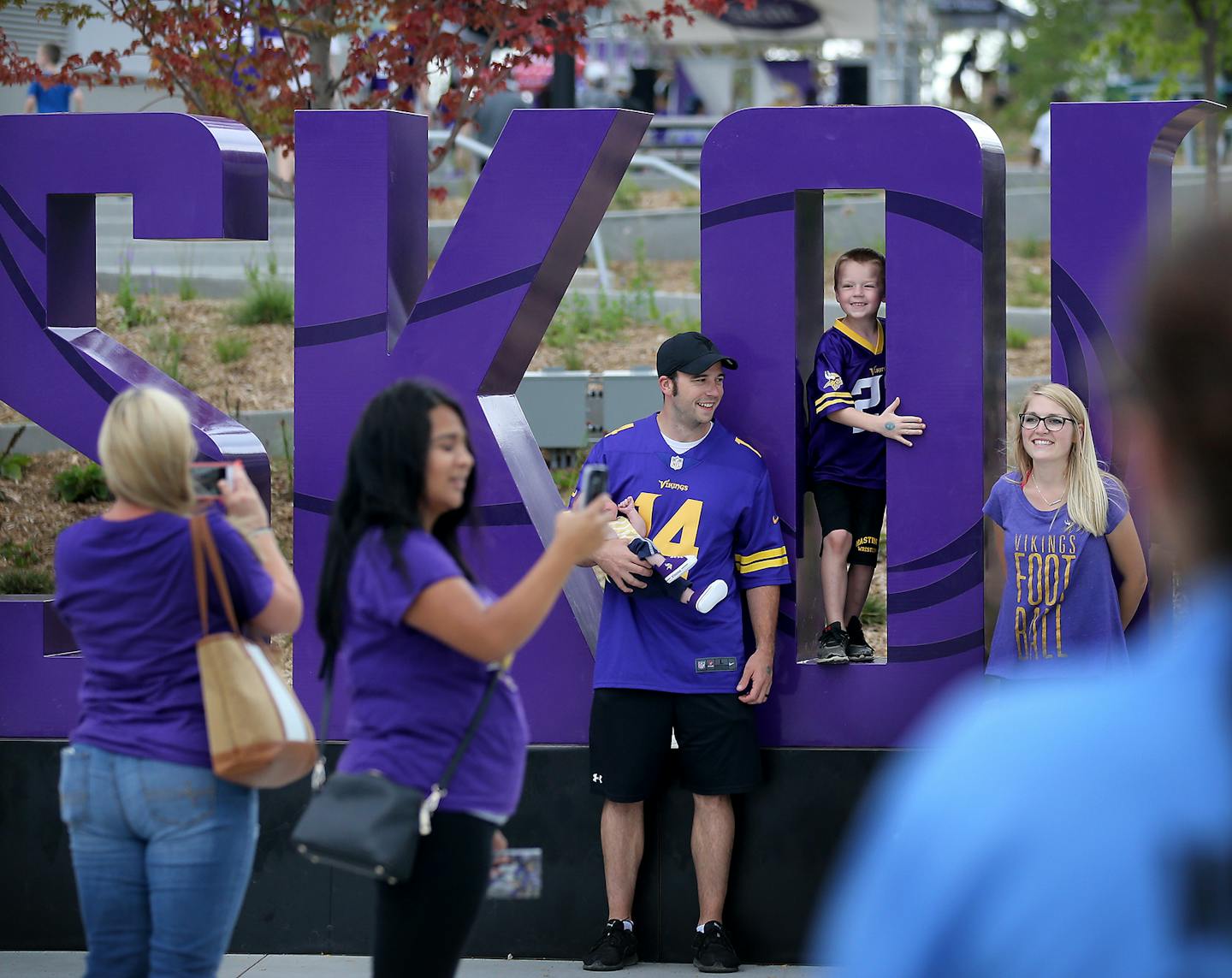 Minnesota Vikings fans pose for photos by a large Skol sign before the start of a Vikings and Jacksonville Jaguars joint practice session Thursday, Aug. 16, 2018, at the TCO Performance Center in Eagan.