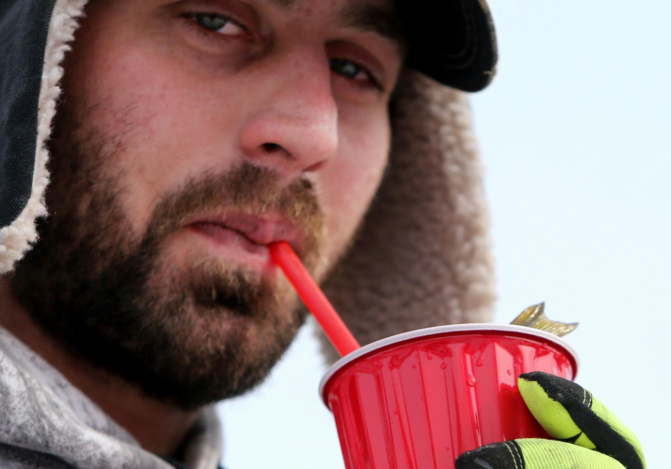 With a perch in a cup, Brandon Knock of Zimmerman uses a straw to aerate the water while waiting to register his fish on Hole in the Day Bay of Gull Lake during the Ice Fishing Extravaganza Saturday, Feb. 6, 2016, in Brainerd, MN.