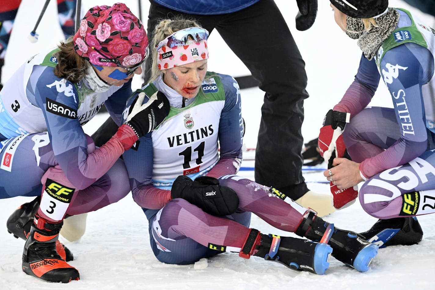 United State's Jessie Diggins, center, is assisted by United States' Rosie Brennan, left, and Sophia Laukli after competing in the women's 20 km mass start freestyle competition, at the cross-country ski World Cup Ruka Nordic Opening event in Kuusamo, Finland, on Sunday, Nov. 26, 2023. (Heikki Saukkomaa/Lehtikuva via AP)