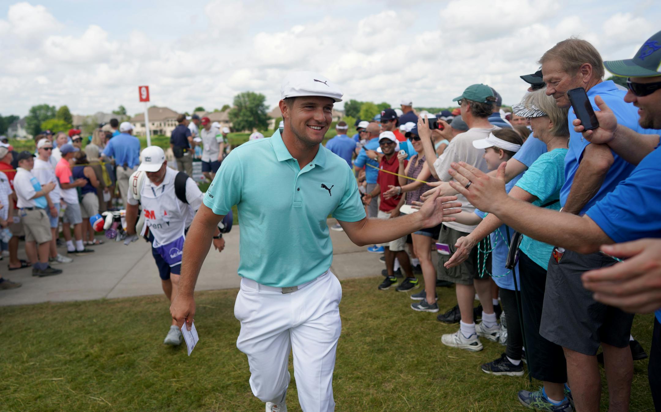 Bryson DeChambeau greeted fans as he left the 9th hole as the leader at -14 during the second round of the 3M Open at TPC Twin Cities.