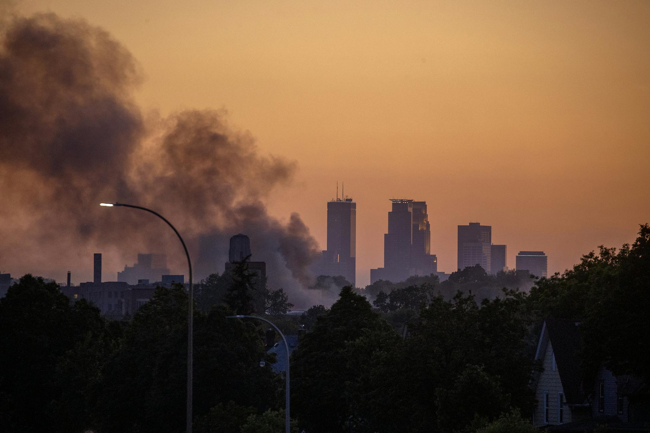The sun set over the Twin Cities as smoke hovers over St. Paul, Minn., along University Avenue, Thursday, May 28, 2020. Protests over the death of George Floyd, a black man who died in police custody, broke out in Minneapolis for a third straight night. (Elizabeth Flores/Star Tribune via AP)