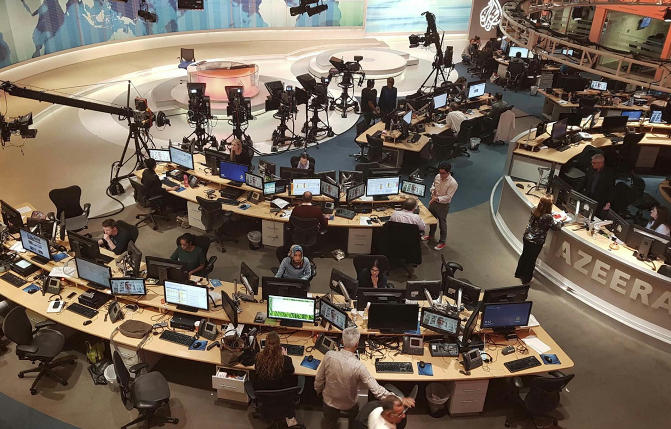 In this Thursday, June 8, 2017 photo, Al-Jazeera staff work at their TV station in Doha, Qatar. The Arab news network Al-Jazeera has been thrust into the center of the story this week as Qatar came under virtual siege by its Gulf neighbors, pressuring it to shut down the TV channel that has infuriated them with its coverage for 20 years (AP Photo/Malak Harb) ORG XMIT: MIN2017071412063831