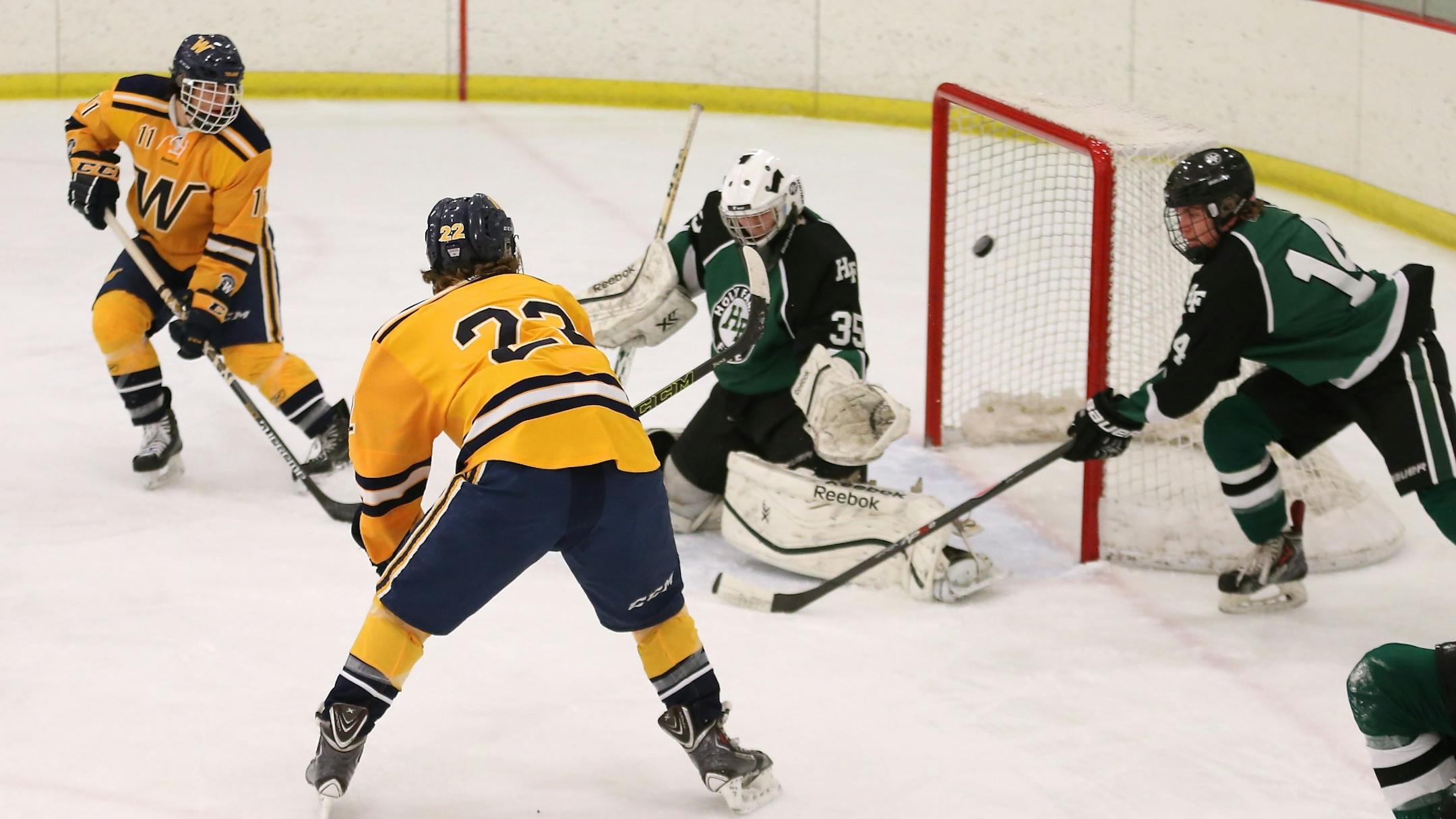 Wayzata's Griffin Ness (22) backhands the puck top shelf to score the opening goal in the Trojans' 4-2 win over Holy Family. The freshman had a goal and an assist Monday night. Photo by Brian W Nelson