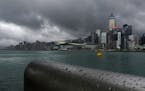 Rain droplets line a railing along the waterfront of Victoria Harbour in Hong Kong Wednesday, Aug. 19, 2020. Typhoon Higos weakened to a strong topica
