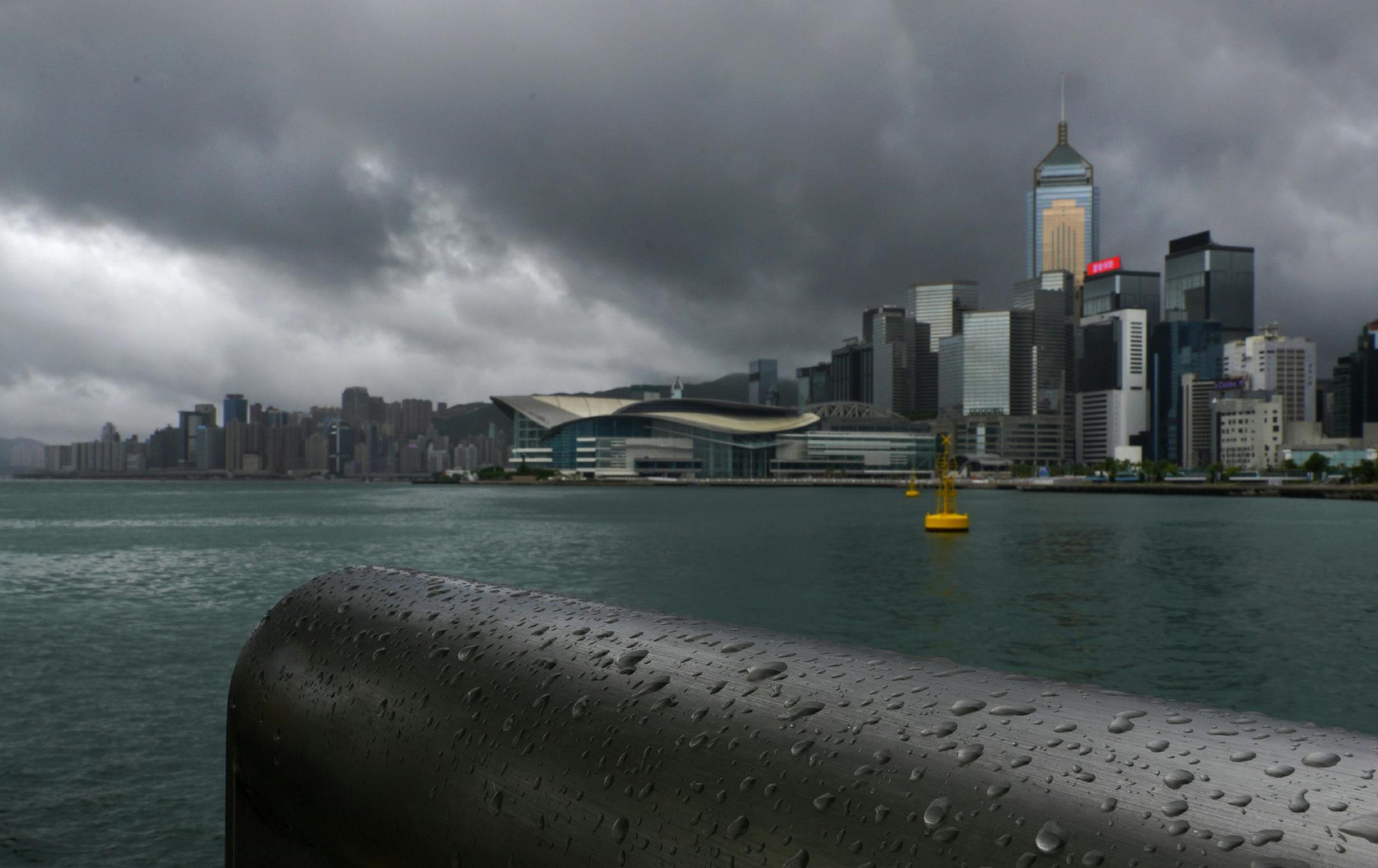 Rain droplets line a railing along the waterfront of Victoria Harbour in Hong Kong Wednesday, Aug. 19, 2020. Typhoon Higos weakened to a strong topical storm after making landfall in Zhuhai city on Wednesday morning on China's southern coast. (AP Photo/Vincent Yu)