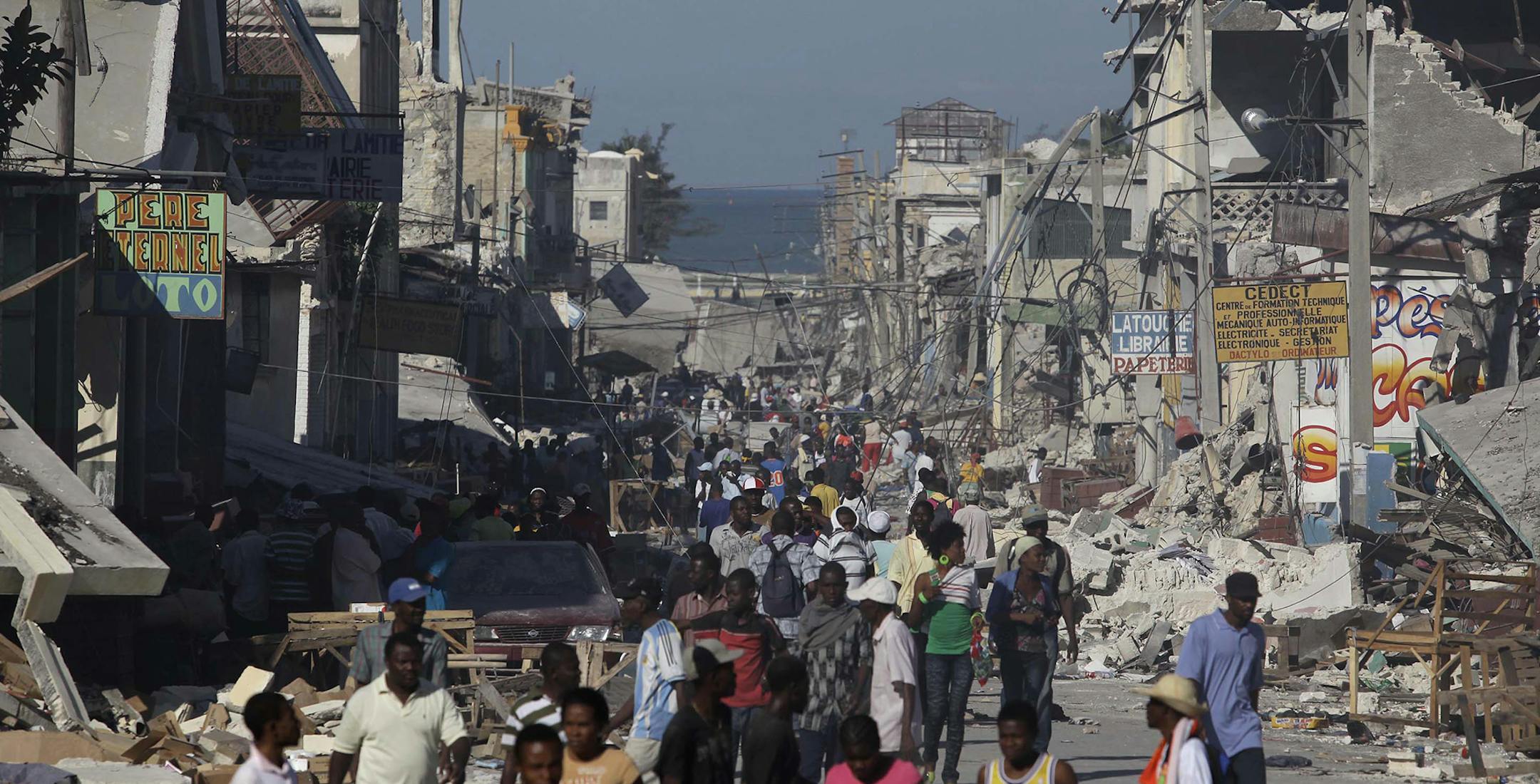 Earthquake survivors walk amidst collapsed buildings and rubble in downtown Port-Au-Prince, Thursday, Jan. 14, 2010. (AP Photo/Julie Jacobson) ORG XMIT: MIN2015010912391368