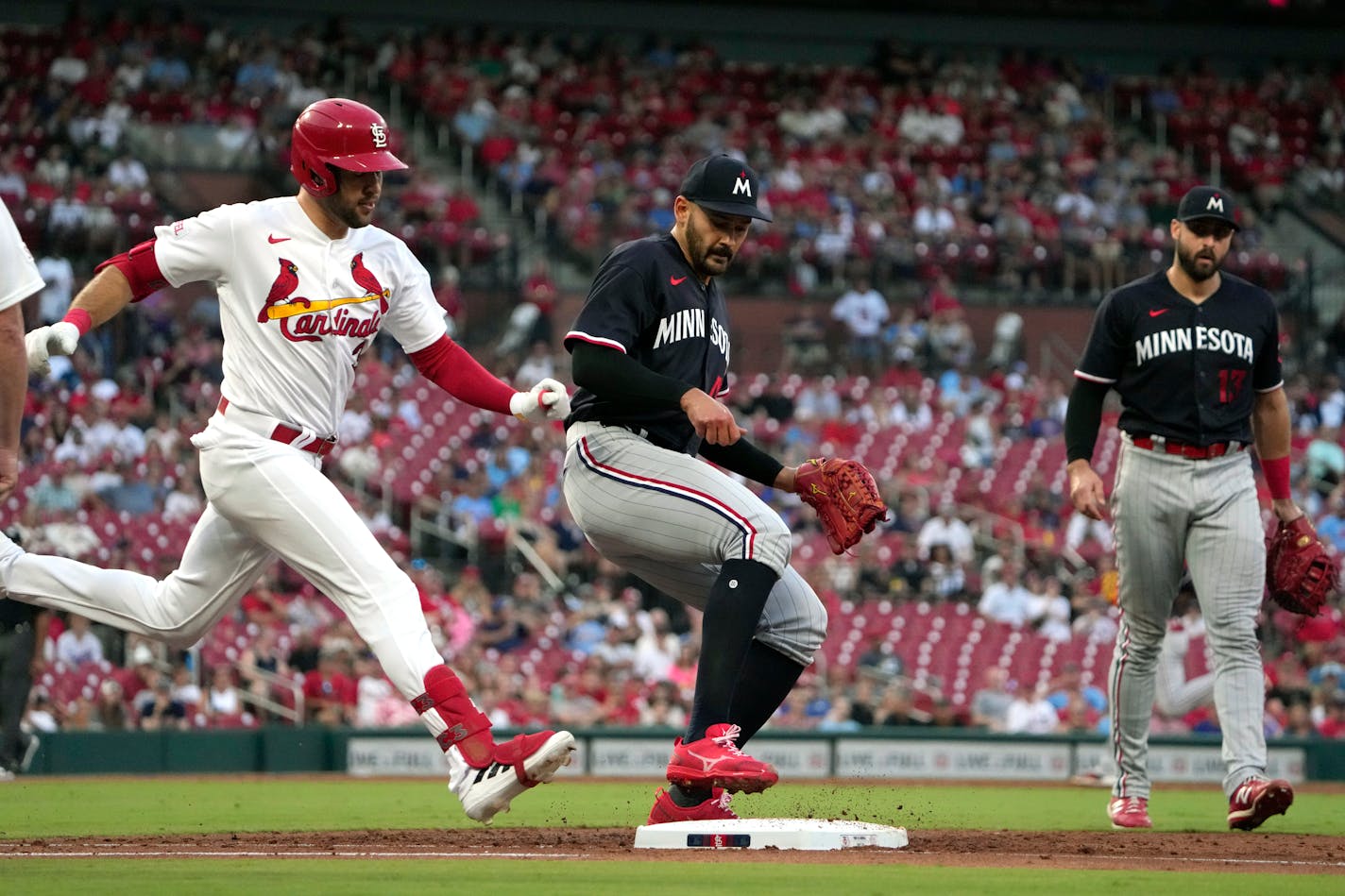 St. Louis Cardinals' Dylan Carlson, left, is forced out at first by Minnesota Twins starting pitcher Pablo Lopez as Twins first baseman Joey Gallo, right, watches during the third inning of a baseball game Tuesday, Aug. 1, 2023, in St. Louis. (AP Photo/Jeff Roberson)