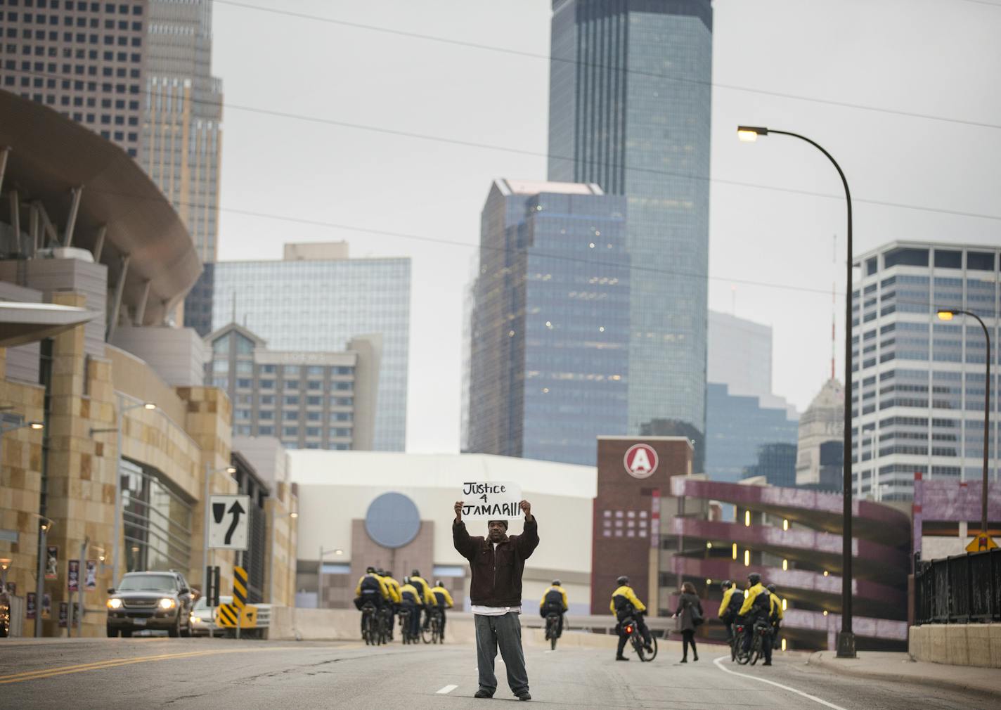 Donnie Straub holds a sign as the Jamar Clark protest moves downtown from north Minneapolis. ] (Leila Navidi/Star Tribune) leila.navidi@startribune.com BACKGROUND INFORMATION: Wednesday, March 30, 2016. Tensions mount in Minneapolis following the announcement that there will be no charges against Minneapolis police officers in the shooting death of Jamar Clark.