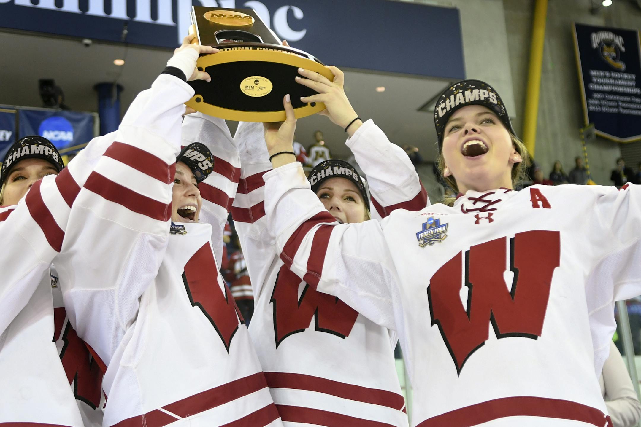 Wisconsin's Sophia Shaver, Maddie Rolfes, Annie Pankowski and Emily Clark, from left, hold up the NCAA National Championship trophy after Wisconsin defeated Minnesota 2-0 in the NCAA Division I women's Frozen Four hockey championship game Sunday, March 24, 2019, in Hamden, Conn. (AP Photo/Stephen Dunn)