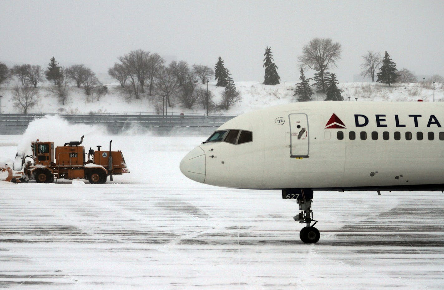 Airport crews worked to clear off the tarmac after a heavy snowfall early Monday morning, Feb. 21, 2011, at Minneapolis-St. Paul International Airport in Minneapolis. Operations were returning to normal at the airport after the storm prompted Delta Airlines to cancel hundreds of flights Sunday, although delays were reported. (AP Photo/Star Tribune, McKenna Ewen) ** ST. PAUL OUT MINNEAPOLIS-AREA TV OUT MAGS OUT ** ORG XMIT: MIN2016020112141625