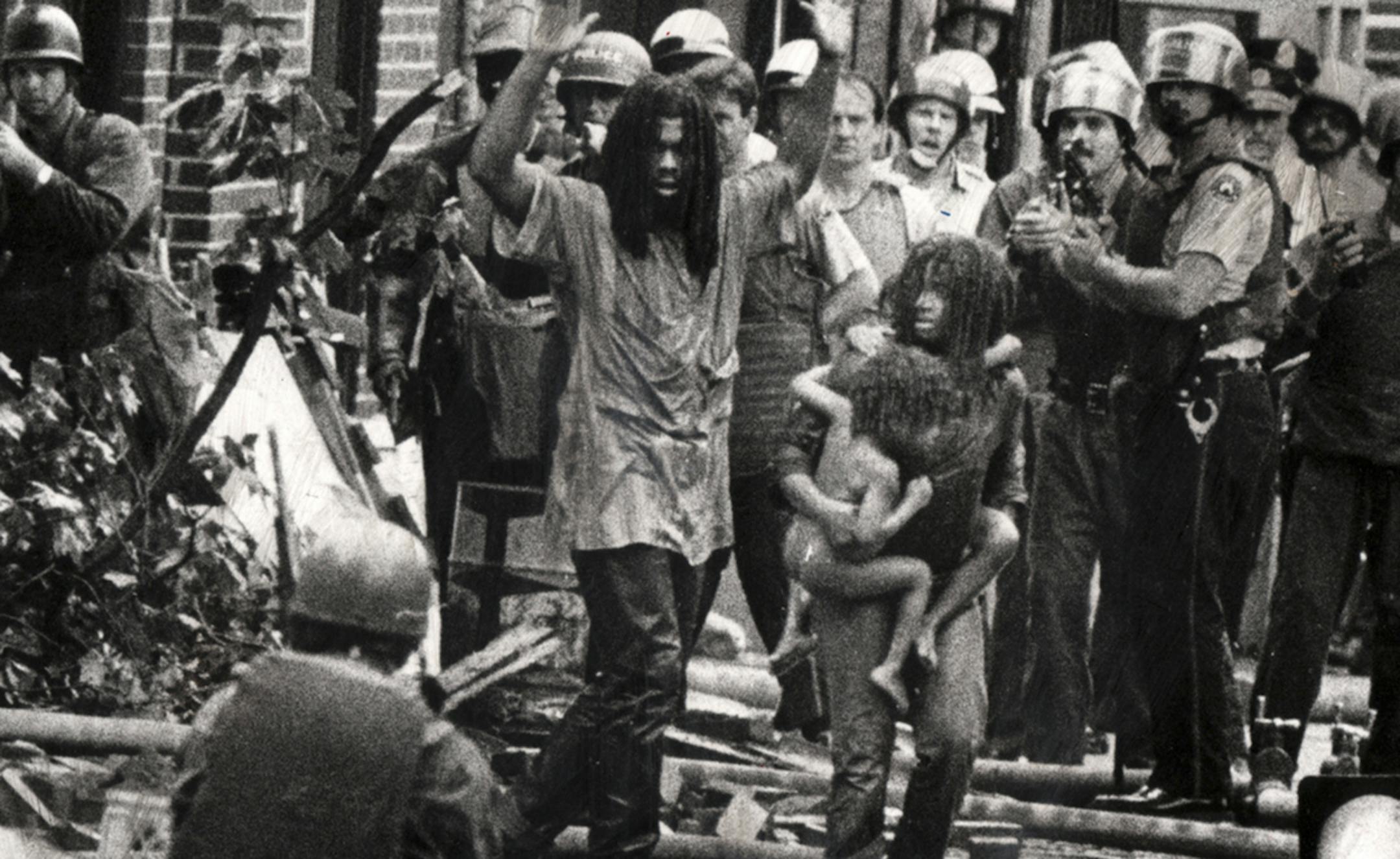 Members of the radical group Move and children in a 1978 confrontation in a scene from "Le the Fire Burn," a film directed by Jason Osder, in an undated handout image. The film about Move and its 1985 bombing by the Philadelphia police, consists entirely of found footage. (Sam Psoras via The New York Times) -- NO SALES; FOR EDITORIAL USE ONLY WITH STORY SLUGGED FILM FIRE ADV29 BY JOHN ANDERSON. ALL OTHER USE PROHIBITED. -- PHOTO MOVED IN ADVANCE AND NOT FOR USE - ONLINE OR IN PRINT - BEFORE SEPT
