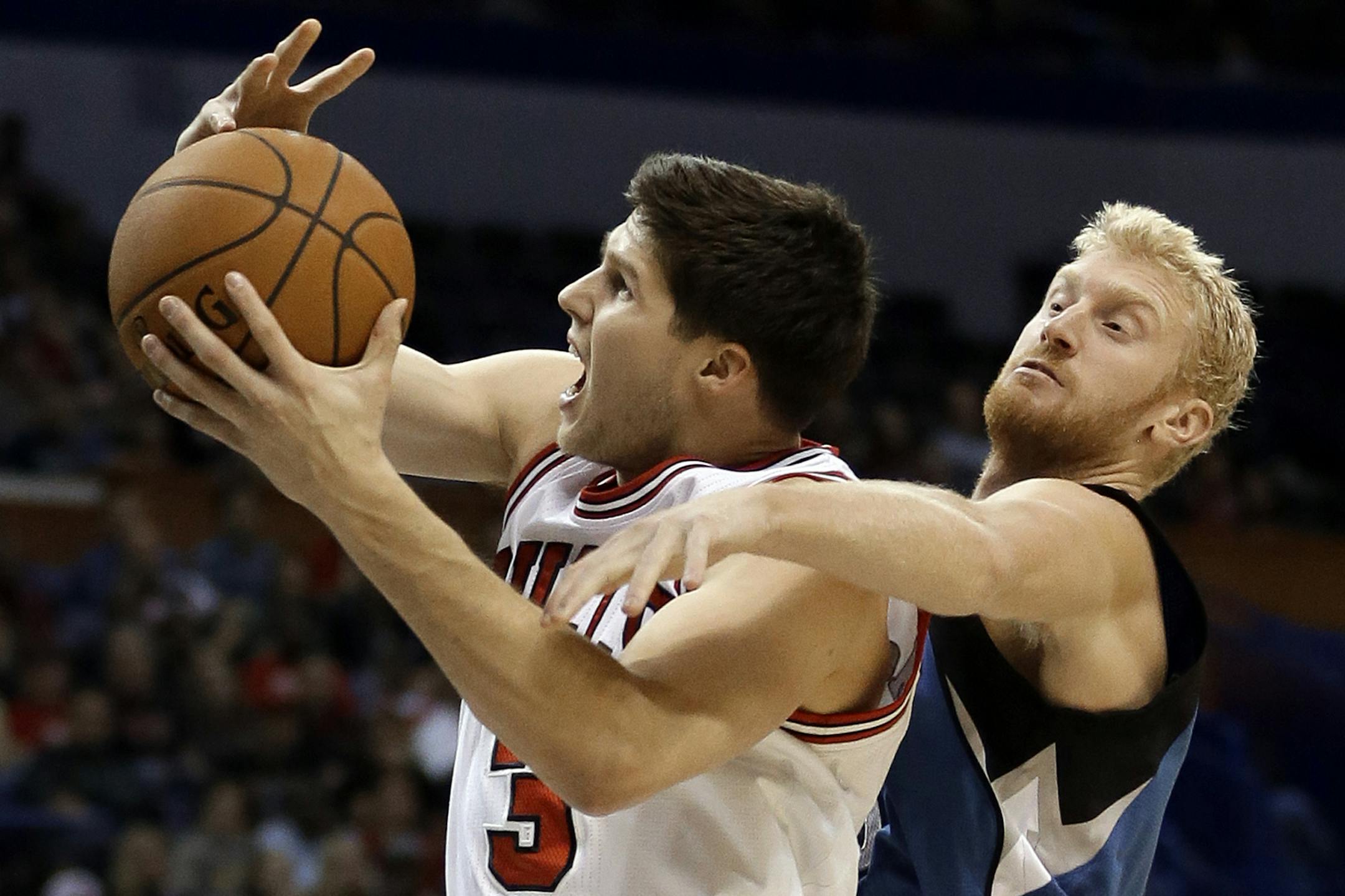 Chicago Bulls' Doug McDermott, left, is fouled on his way to the basket by Minnesota Timberwolves' Chase Budinger during the first half of a preseason NBA basketball game Friday, Oct. 24, 2014, in St. Louis. (AP Photo/Jeff Roberson)