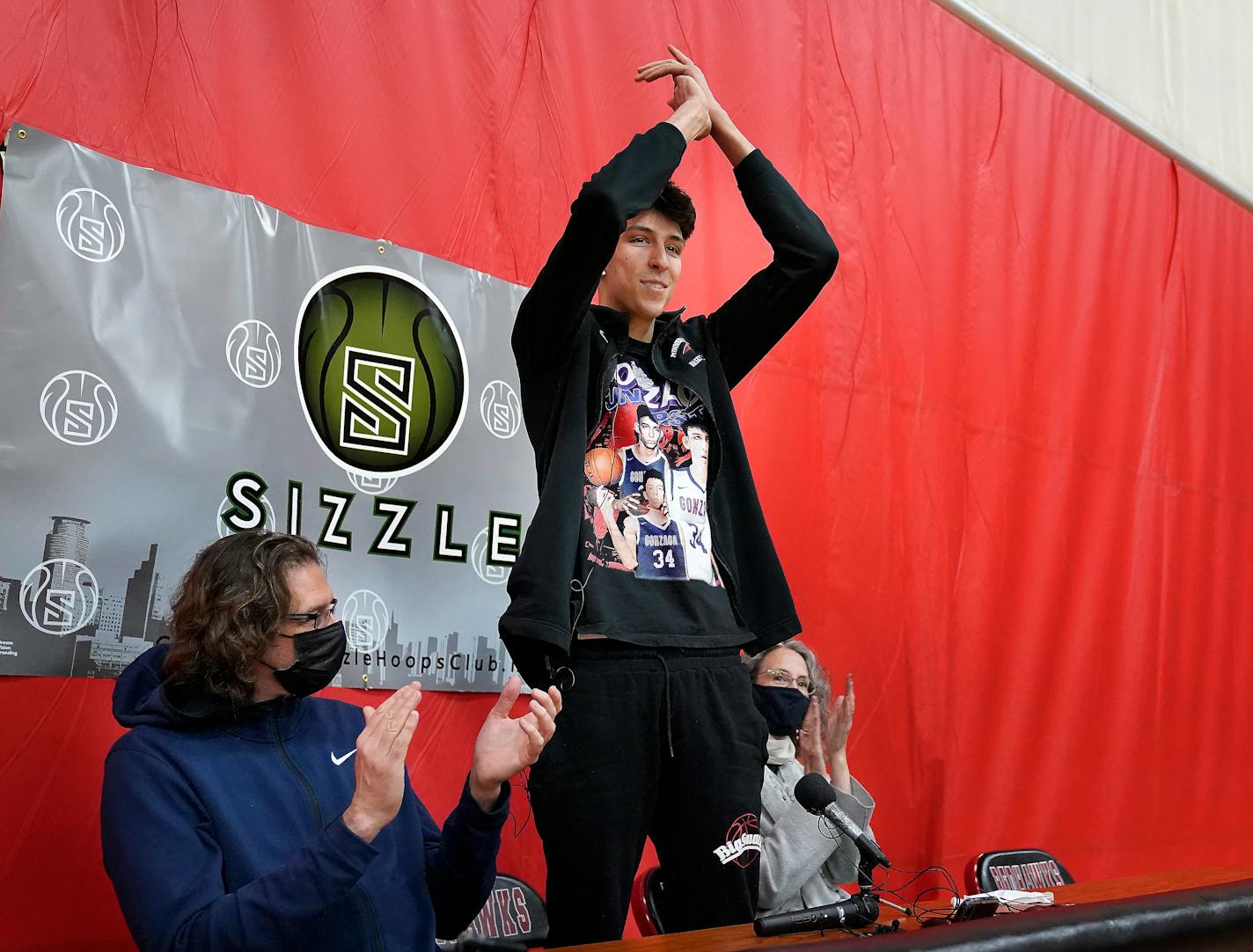 Minnehaha Academy's Chet Holmgren, the No. 1 NCAA college basketball recruit in the country, gestures during a press conference where he announced he will be attending Gonzaga University to play basketball, Monday, April 19, 2021, in Minneapolis. Chet is flanked by his father, David Holmgren, left, and mother, Sarah Harris, right. (David Joles/Star Tribune via AP)