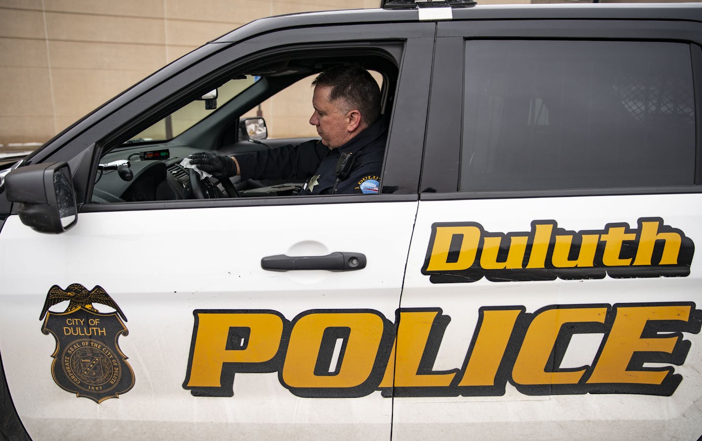 Duluth police Sgt. Steven Ring disinfected his squad car after his shift. The department has been hit by soaring numbers in the Northland, though it won't release totals.