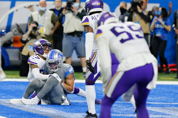 Detroit Lions wide receiver Amon-Ra St. Brown (14), defended by Minnesota Vikings cornerback Cameron Dantzler (27) catches a 11-yard pass for a touchd
