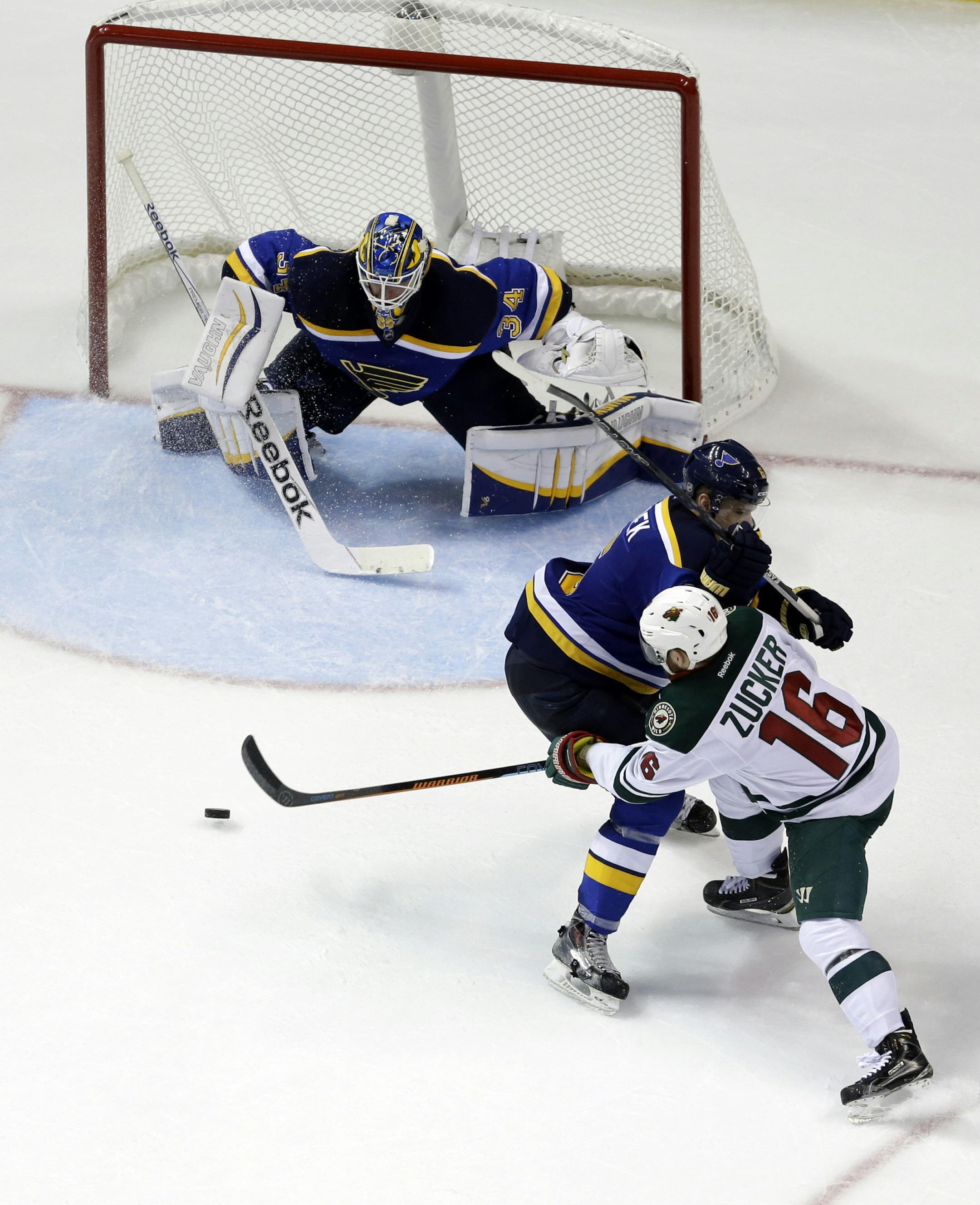 Minnesota Wild's Jason Zucker (16) tries to get his stick on the puck as St. Louis Blues' Zbynek Michalek, of the Czech Republic, and goalie Jake Allen defend during the second period in Game 1 of an NHL hockey first-round playoff series, Thursday, April 16, 2015, in St. Louis. (AP Photo/Jeff Roberson)