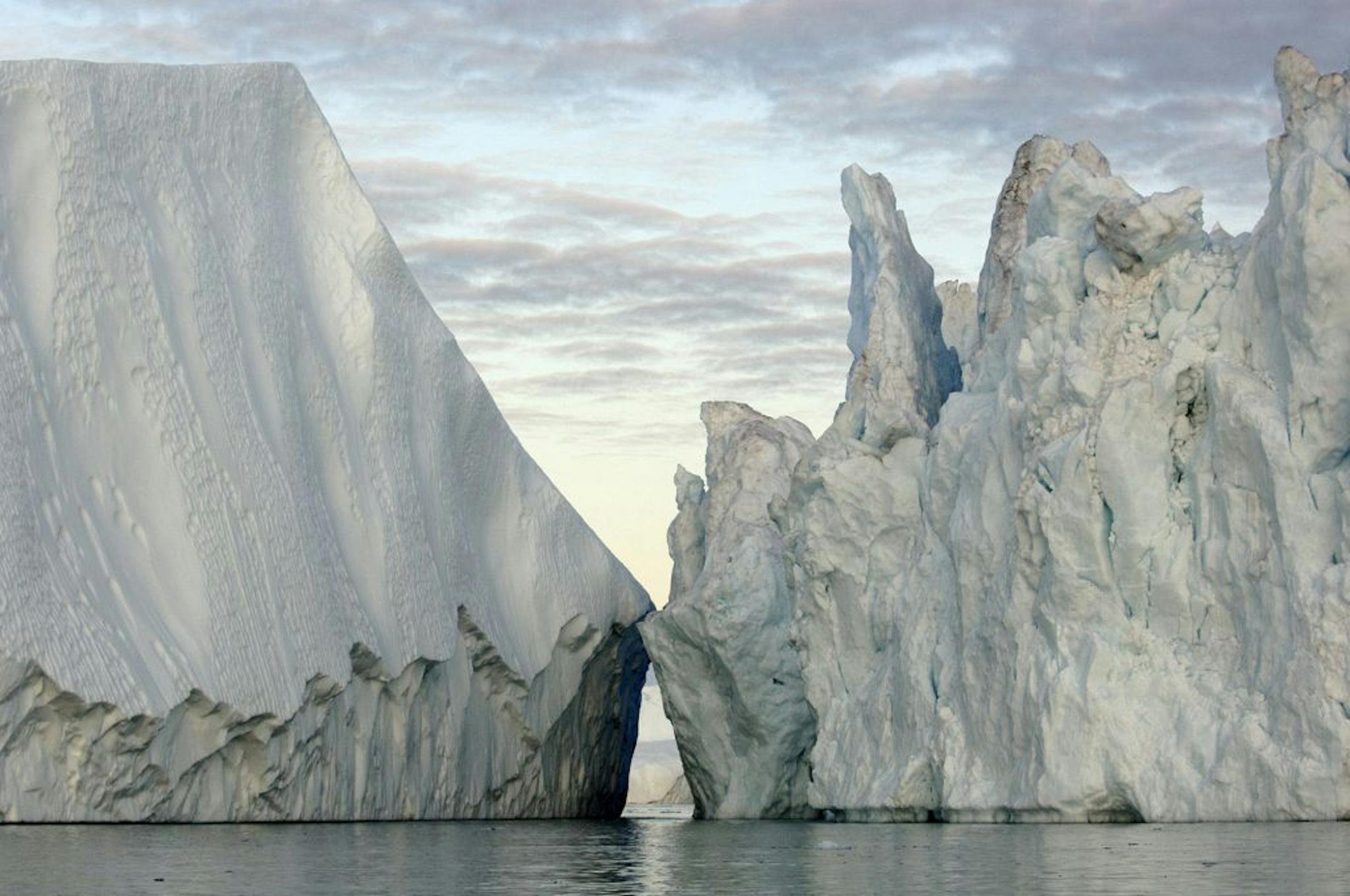 In Disko Bay, Greenland, 20-story high icebergs broken off from the Greenland ice sheet float into the North Atlantic, raising sea level