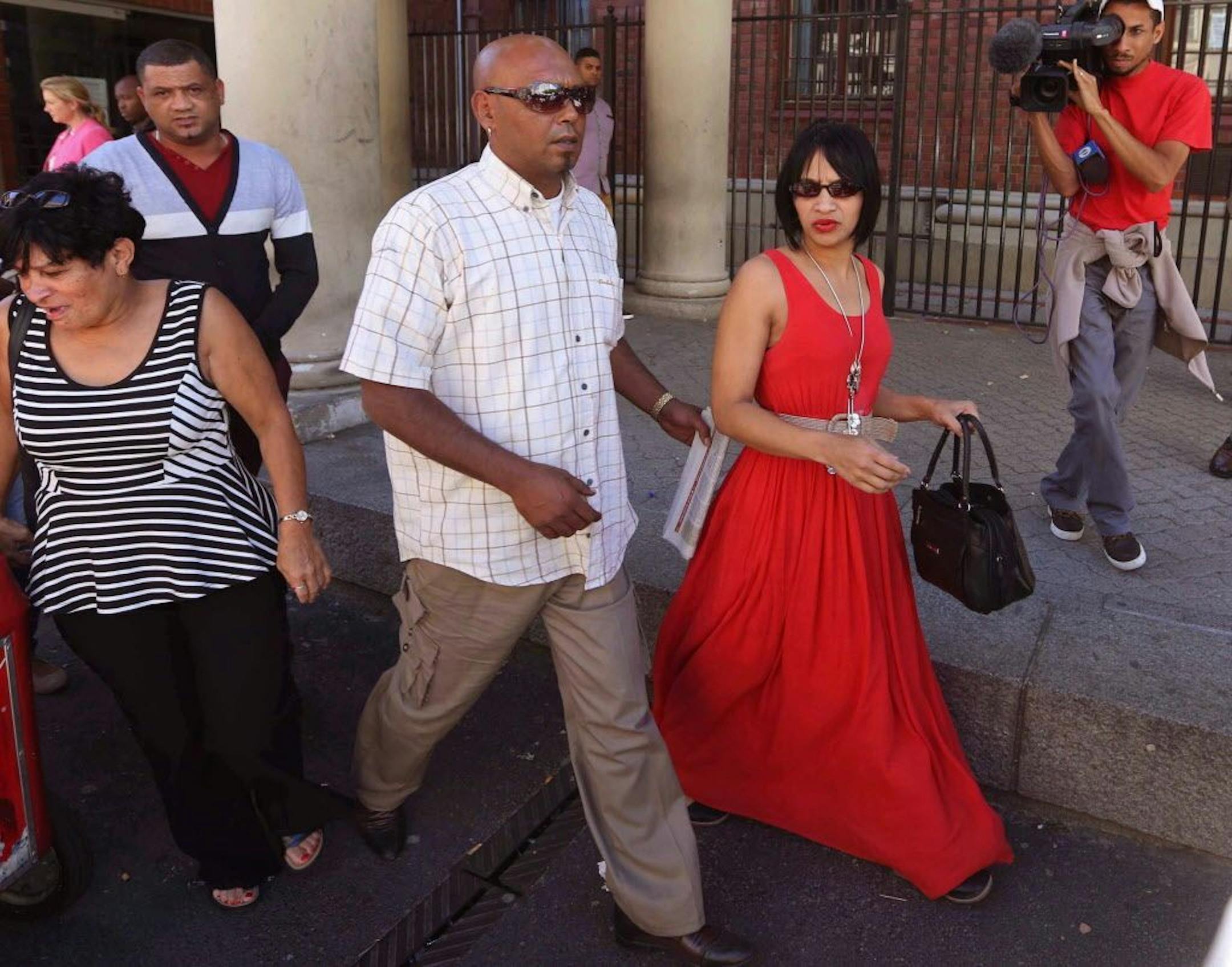 Celeste Nurse, right, the mother of a girl that was kidnapped as a baby 17 years ago, leaves the court after attending the appearance of a woman suspected of the kidnapping in Cape Town, South Africa, Friday, Feb. 27, 2015. Father Morne Nurse, in black, white and grey sweater, walks behind her.