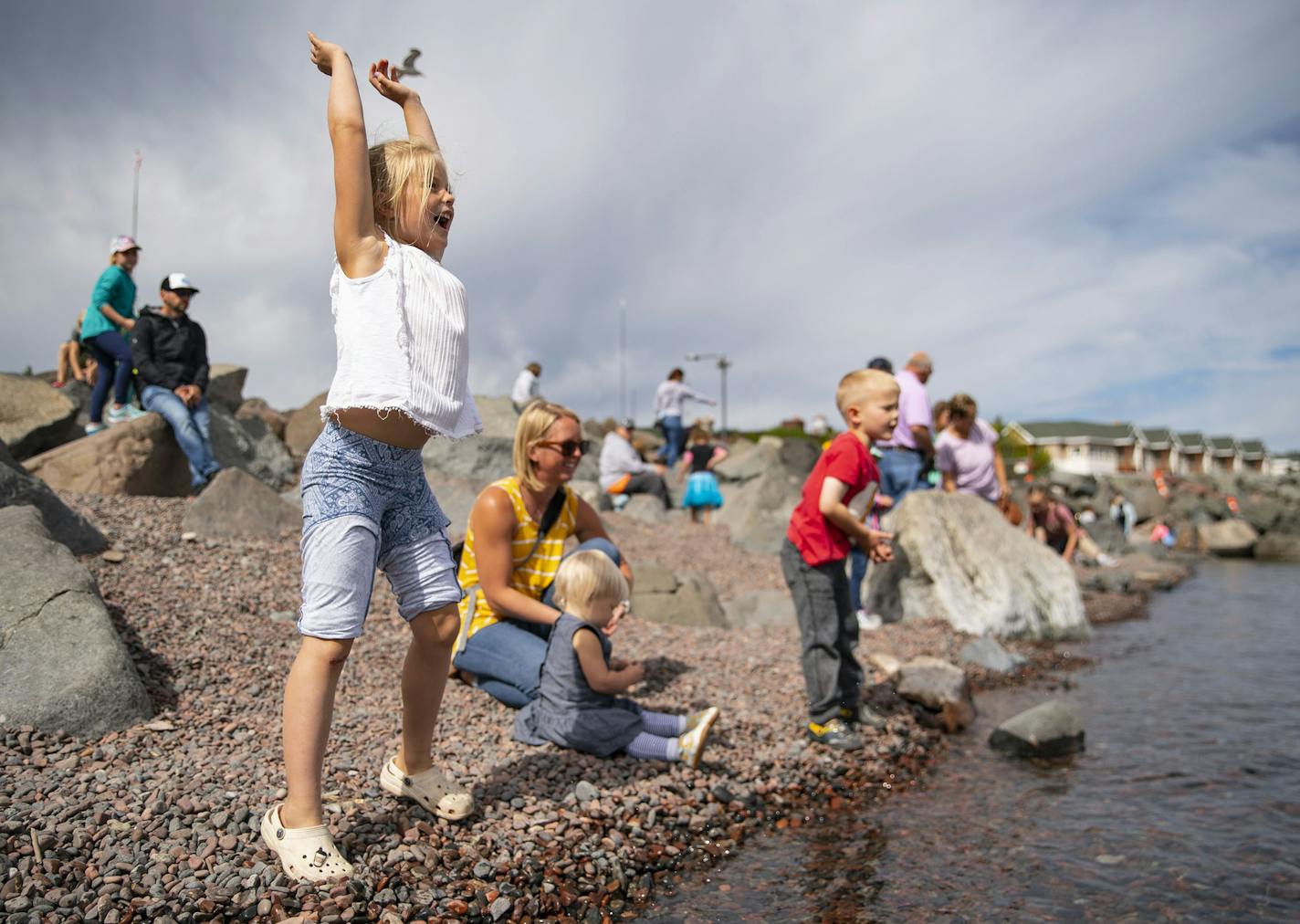 (Left) Haley Lindberg (8) celebrated successfully skipping a rock on Lake Superior in Duluth's Canal Park on Friday. The Lindbergs were visiting the city from Minnetonka, Minn. ] ALEX KORMANN • alex.kormann@startribune.com Though a surge of visitors came to Duluth after July 4, the city's tourism tax collections for that month were still a quarter less than the $1.4 million expected. Hundreds of visitors were out on Friday September 4, 2020 to enjoy the mild and sunny weather in Duluth.