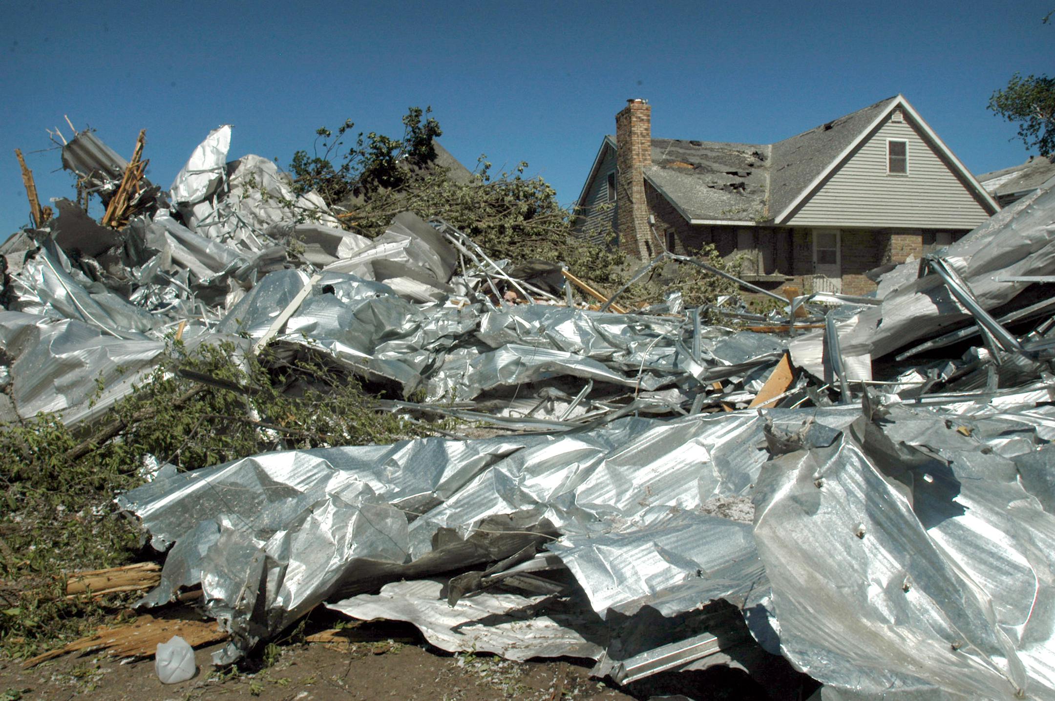 A portion of the Wadena Community Center's roof landed atop Rod Tucker's home (left in photo). The roof was carried about a mile and devasted Tucker's home. At the time he was in the home, in the basement with his dog, The dog ran upstairs and he gave chase. At that moment the house caved in and knocked him down. He fortunately came out of it without any serious injury.