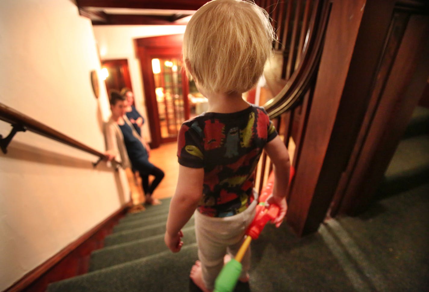 Otto Blaseg, 2, listens from midway up the staircase as his mom, Rachel Blaseg, tries to coax him to come down.