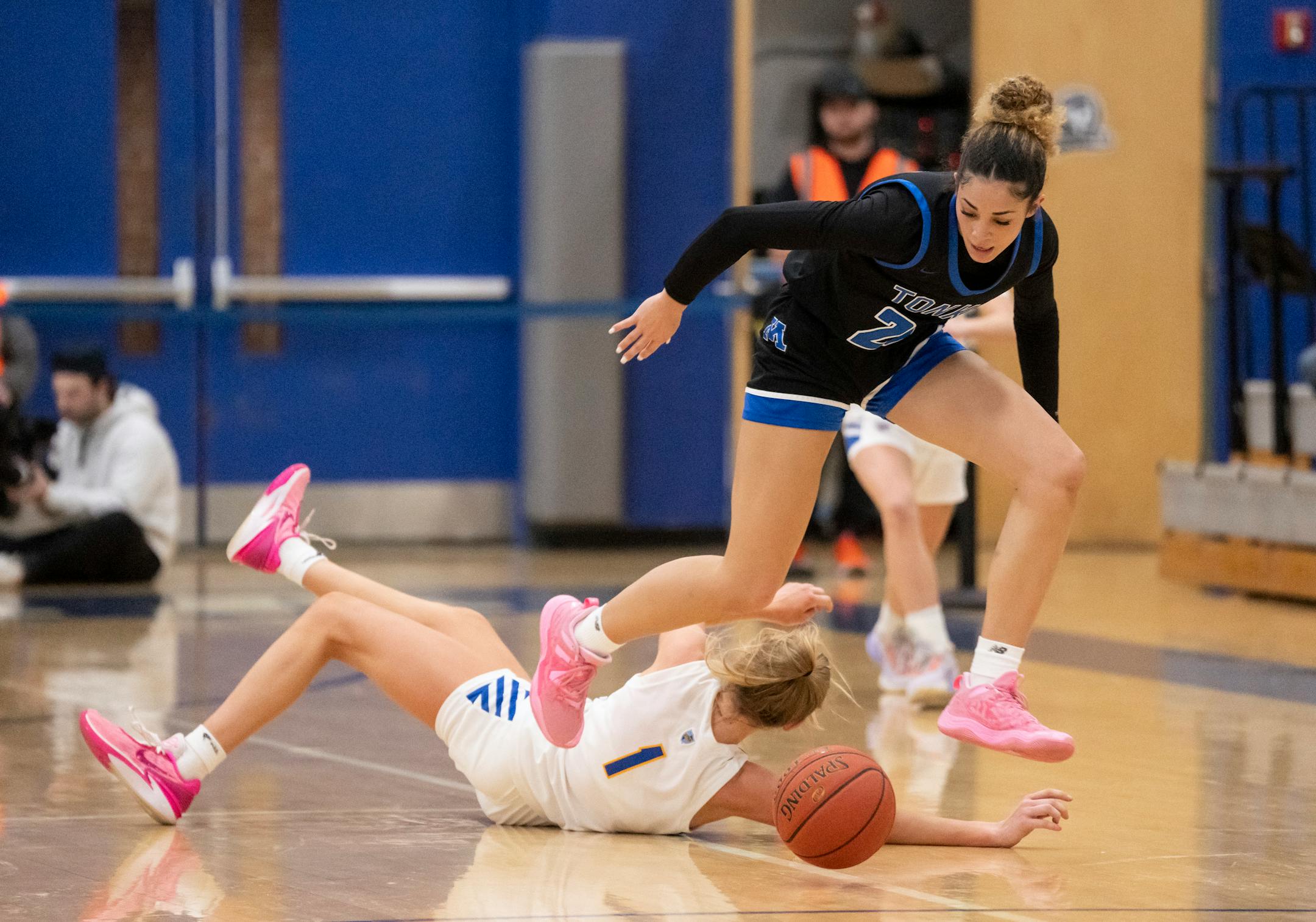 Minnetonka's Aaliyah Crump steps over St. Michael/Albertville's Cali Jahnke to grab a loose ball in the first half. Minnetonka High School hosted St. Michael-Albertville, both undefeated Class 4A girls basketball teams, on Friday, Jan. 12, 2024 in Minnetonka, Minn. ] RENEE JONES SCHNEIDER • renee.jones@startribune.com