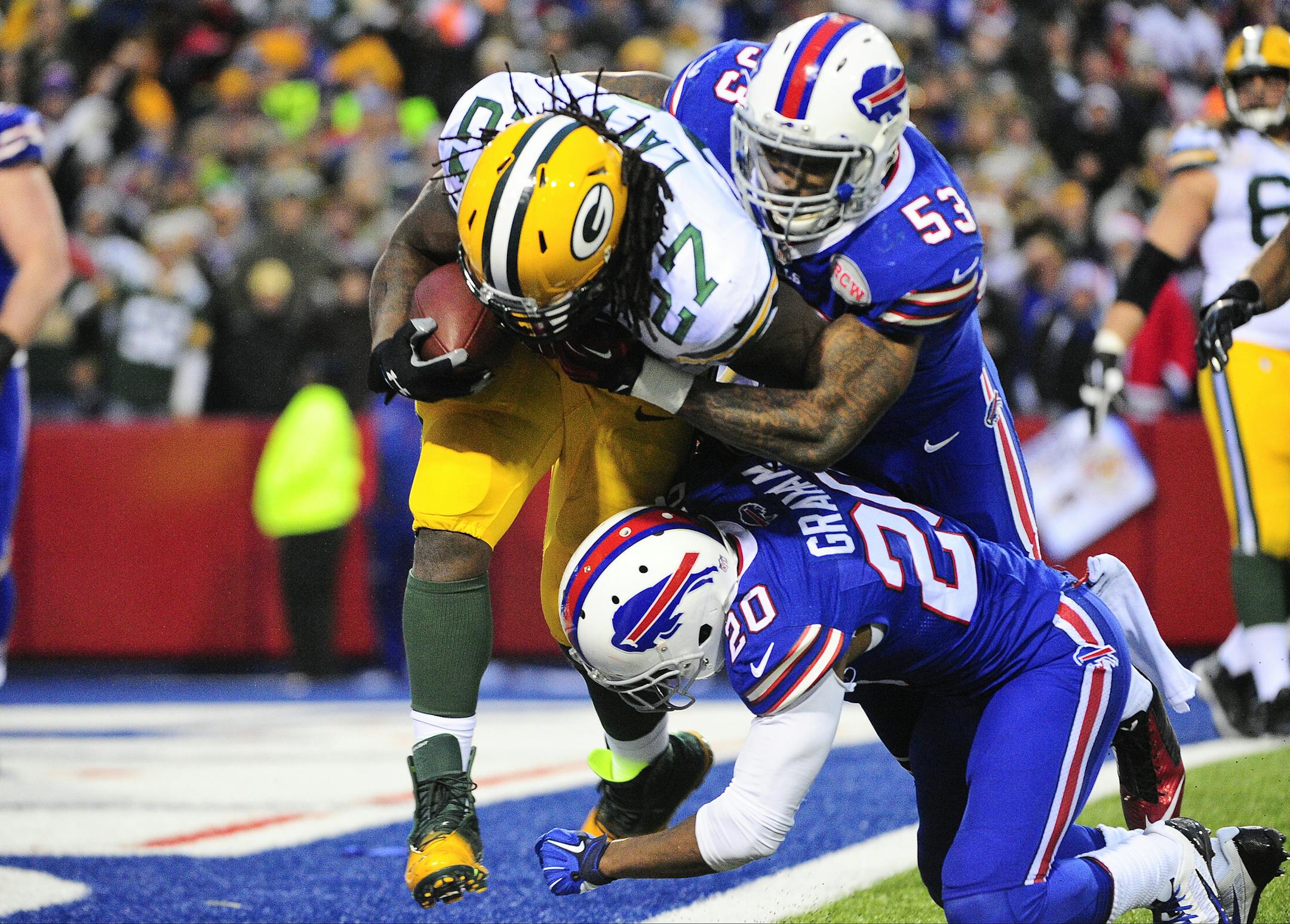 Buffalo Bills outside linebacker Nigel Bradham (53) and Corey Graham (20) tackle Green Bay Packers' Eddie Lacy (27) in the end zone for a safety during the second half of an NFL football game Sunday, Dec. 14, 2014, in Orchard Park, N.Y. The Bills won the game 21-13.(AP Photo/Gary Wiepert)