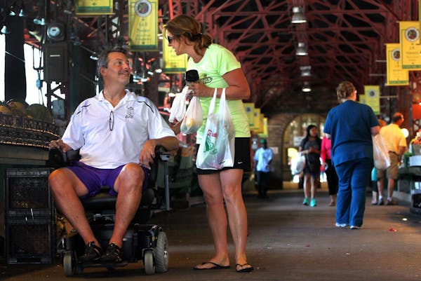 Dave Larson, who suffers from ALS, and his wife, Ann, shop, in St. Louis on July 1, 2014. Larson is undergoing massage treatments to try to slow the a