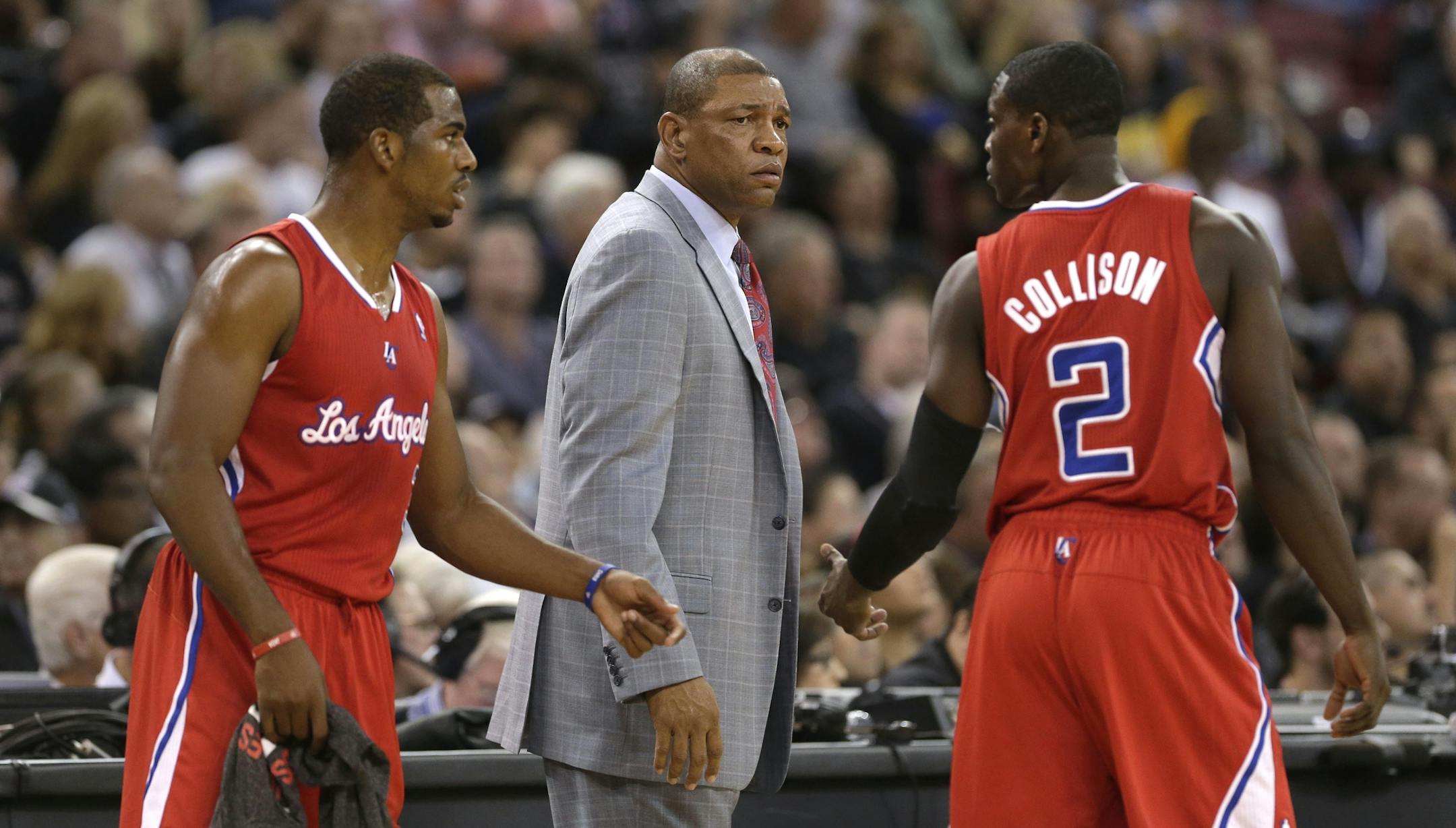Los Angeles Clippers' Chris Paul, left, and Darren Collison, right, talk as head coach Doc Rivers looks on during the first quarter against the Sacramento Kings in a NBA basketball game in Sacramento, Calif., Friday, Nov. 1, 2013.(AP Photo/Rich Pedroncelli)