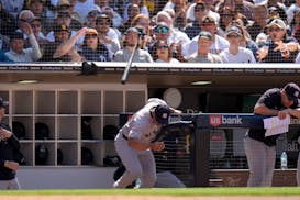 New York Yankees third base coach Luis Rojas ducks as a bat from San Diego Padres' Luis Campusano flies over the dugout during the seventh inning of a