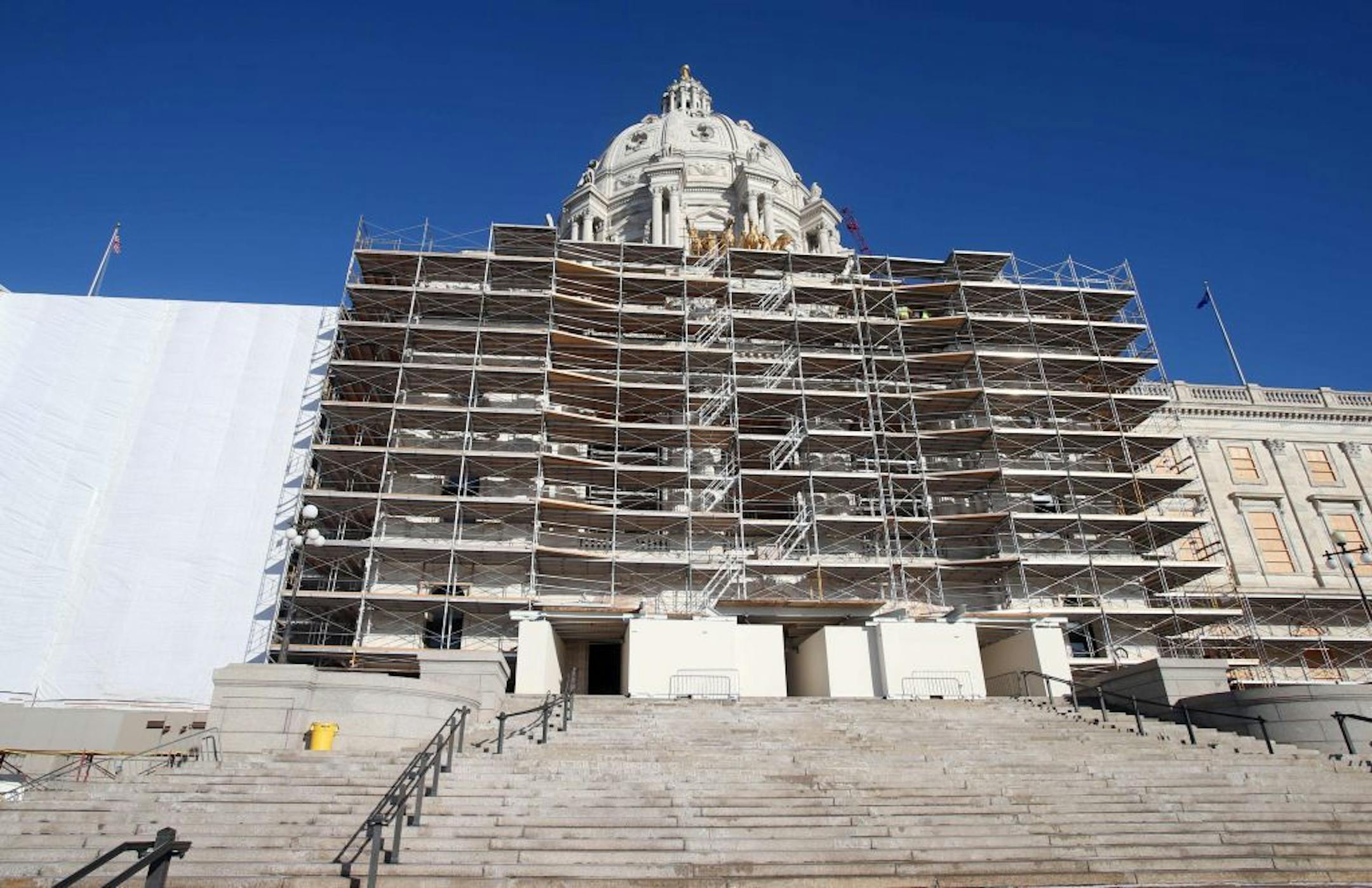 ADVANCE FOR SUNDAY, NOV. 30 2014, AT 12:01 A.M. CST. AND THEREAFTER- In this photo taken Tuesday, Nov. 25, 2014, protective wrap covering, left, and scaffolding hid the graceful lines of the Minnesota state Capitol as the massive renovation continues in St. Paul, Minn. The working sections of the building have been so disrupted by the overhaul that lawmakers will find the going tough this upcoming session.