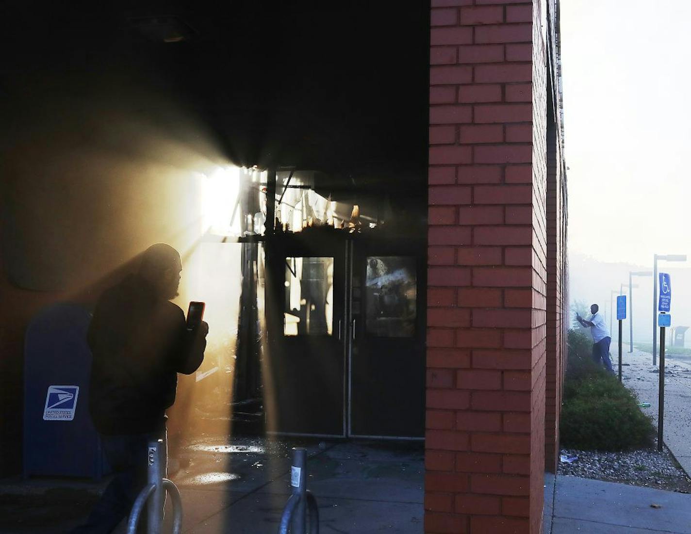 People look over the fire-gutted US Post Office along 31st St. and 1st Ave. Saturday, May 30, 2020, in Minneapolis, MN.