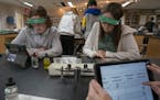 Minnetonka High School ninth-graders Charley Mayes, left, and Grace Coleman worked on iPads during an honors physical science class last month. Teache