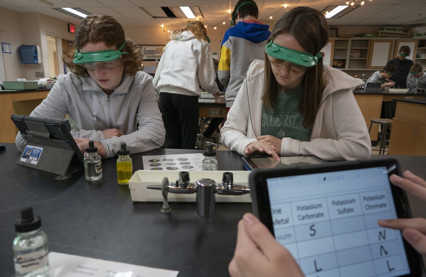 Minnetonka High School ninth-graders Charley Mayes, left, and Grace Coleman worked on iPads during an honors physical science class last month. Teachers list many benefits from such technology, but research is mixed.