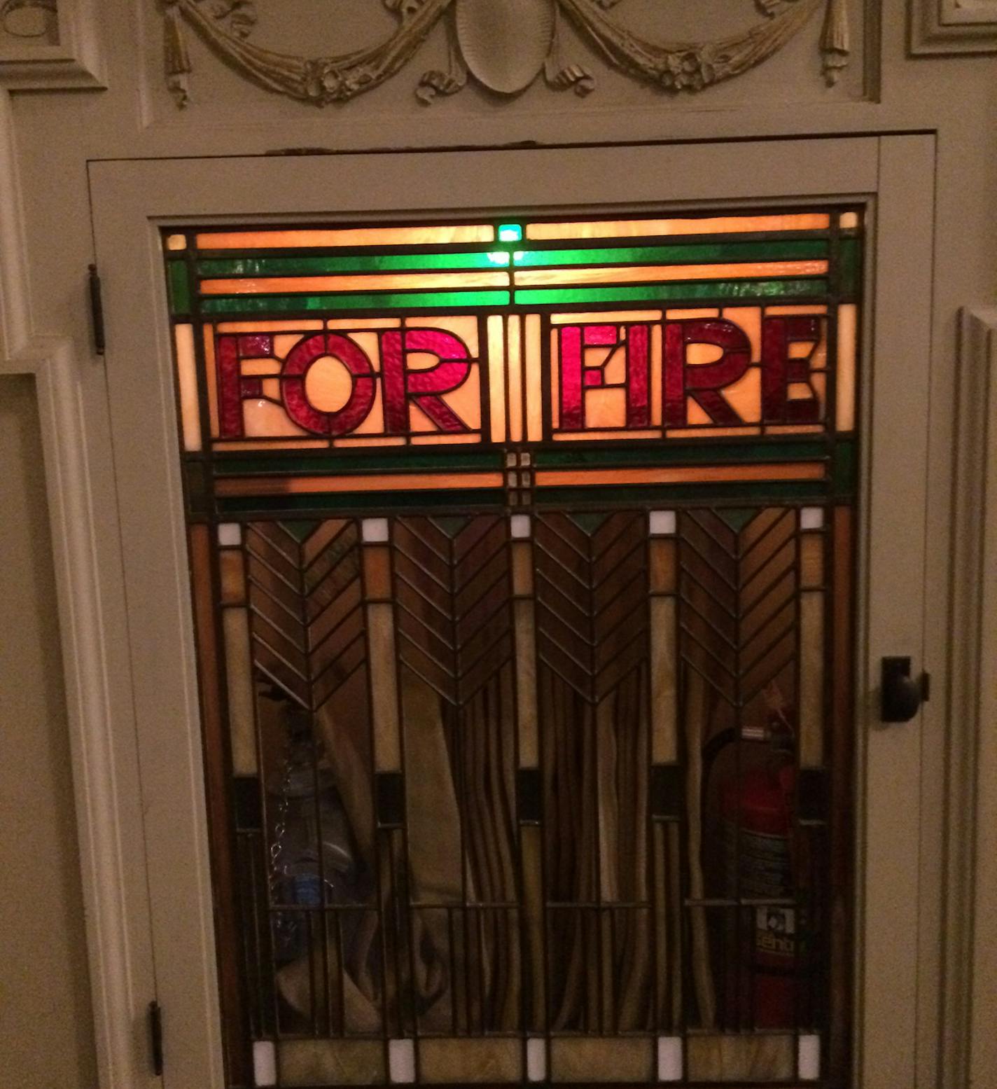 Fire extinguishers in the auditorium at Hibbing High School are housed in stained-glass cases.