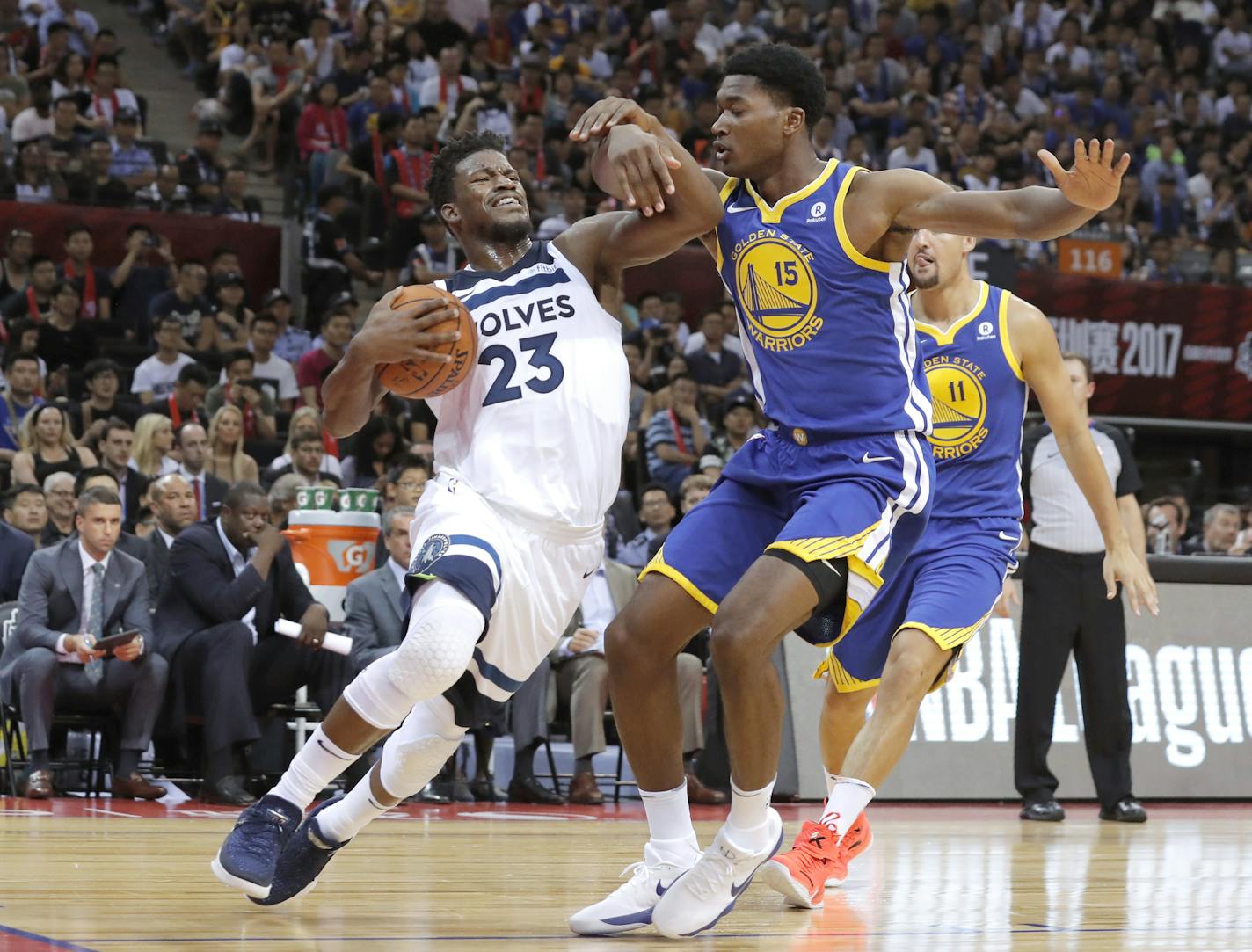 Minnesota Timberwolves' Jimmy Butler, left, drives past Golden State Warriors' Damian Jones during the basketball match of the 2017 NBA Global Games in Shenzhen, south China's Guangdong province, Thursday, Oct. 5, 2017. (AP Photo/Kin Cheung)