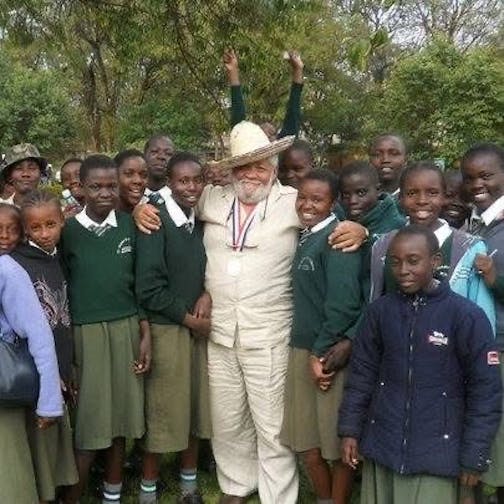 Wallace "Jack" Jackman takes a picture with children in Kenya after helping to get a firetruck into the country.