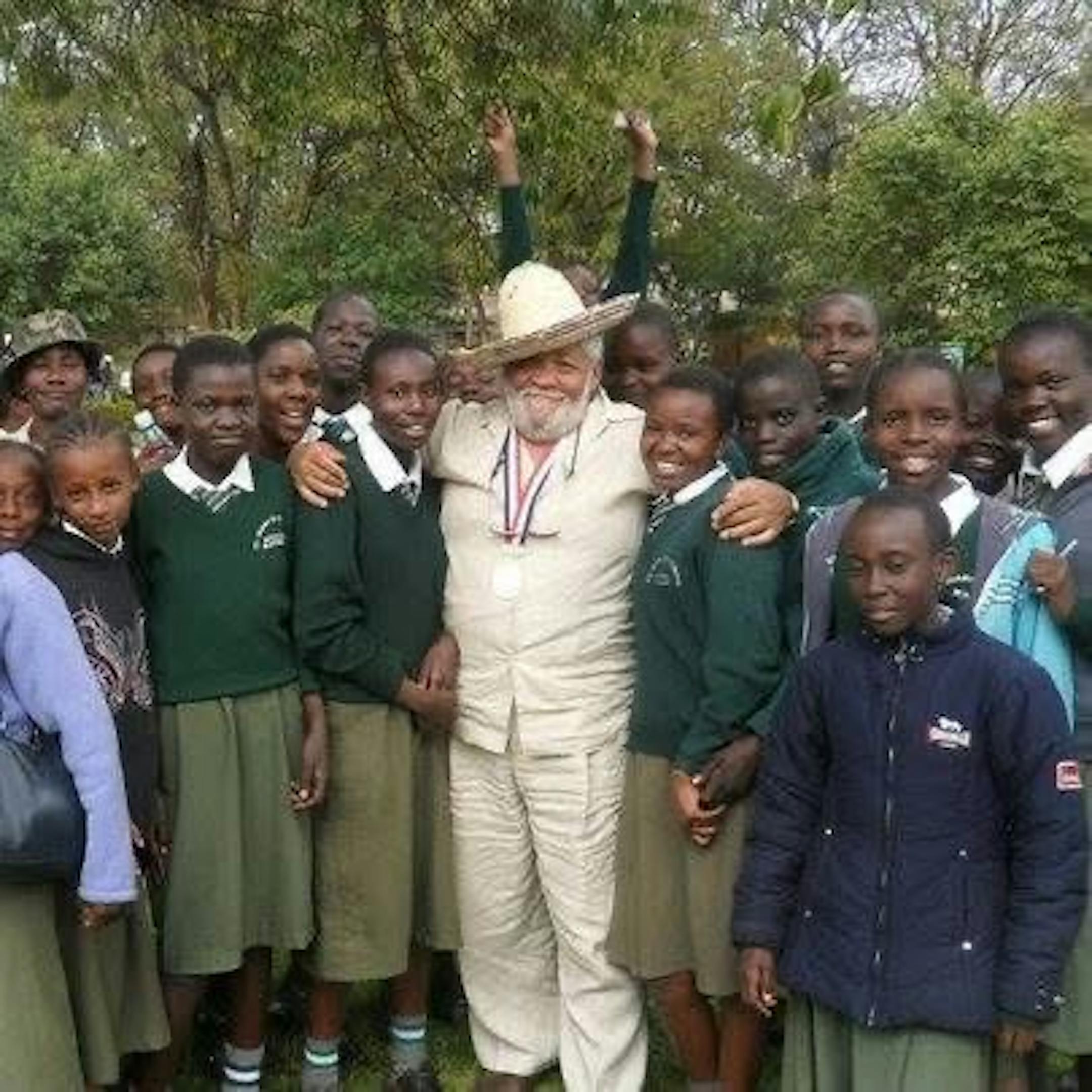 Wallace "Jack" Jackman takes a picture with children in Kenya after helping to get a firetruck into the country.
